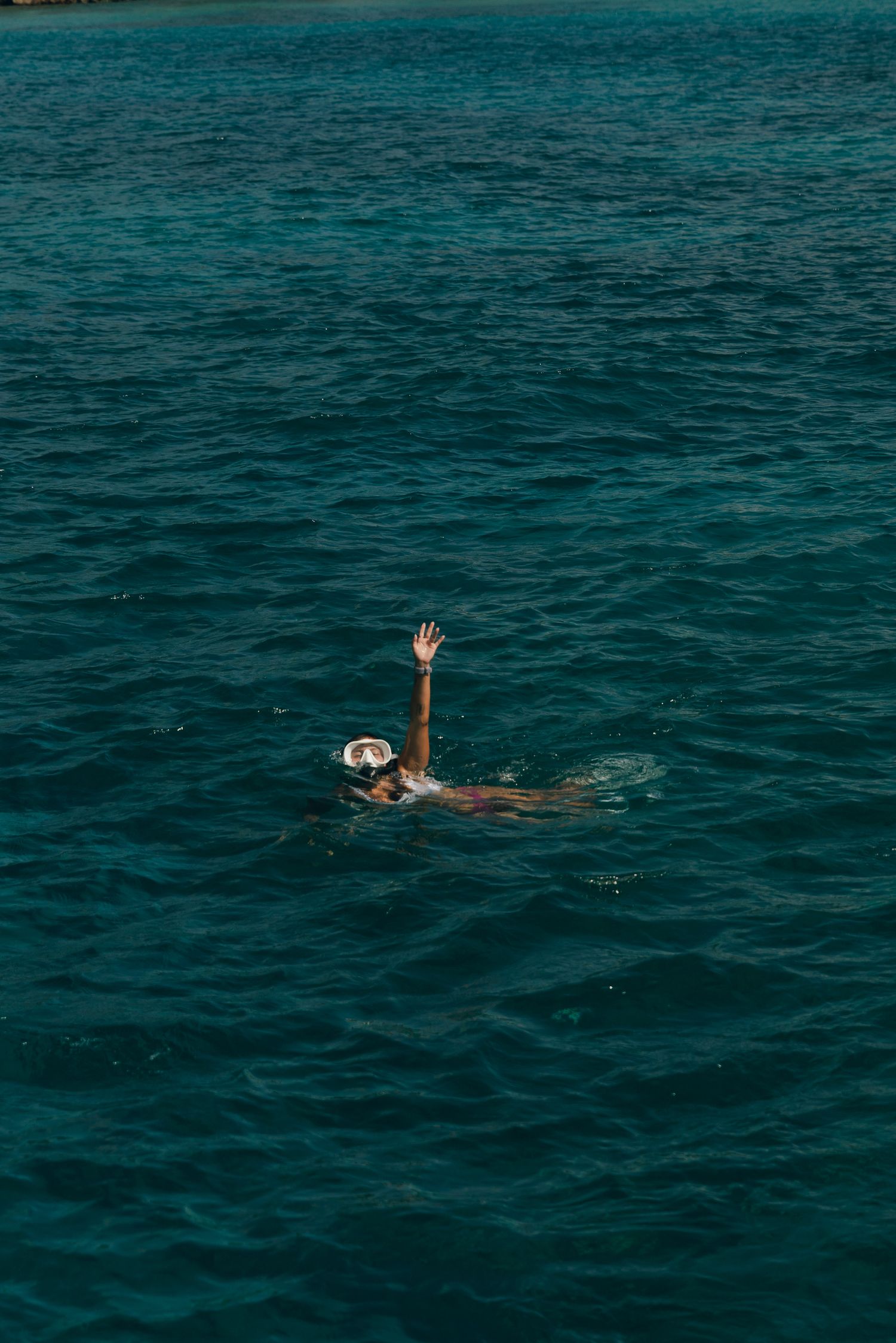 girl waving while swimming in the ocean, Oahu, Hawaii