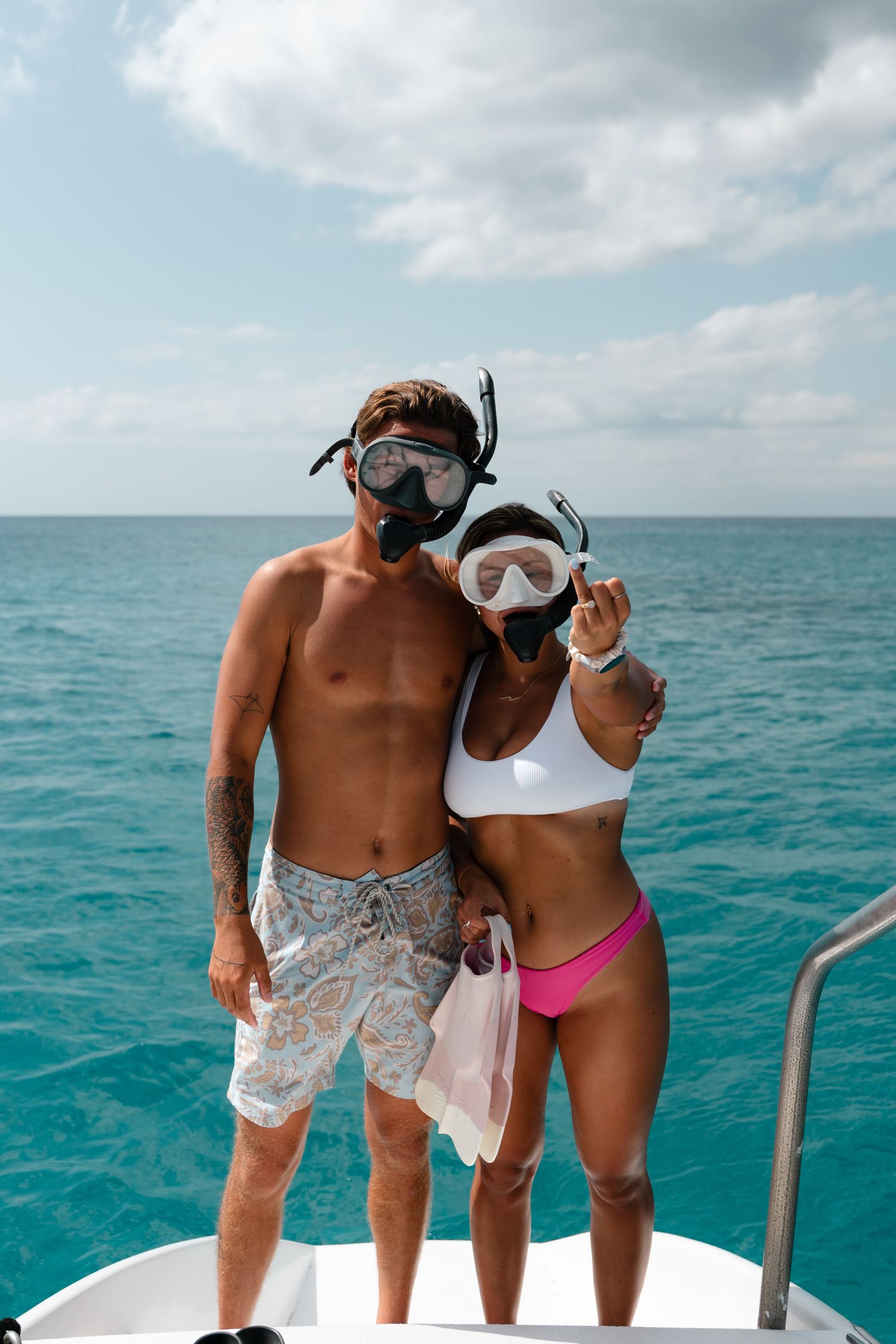 couple on boat showing off their rings