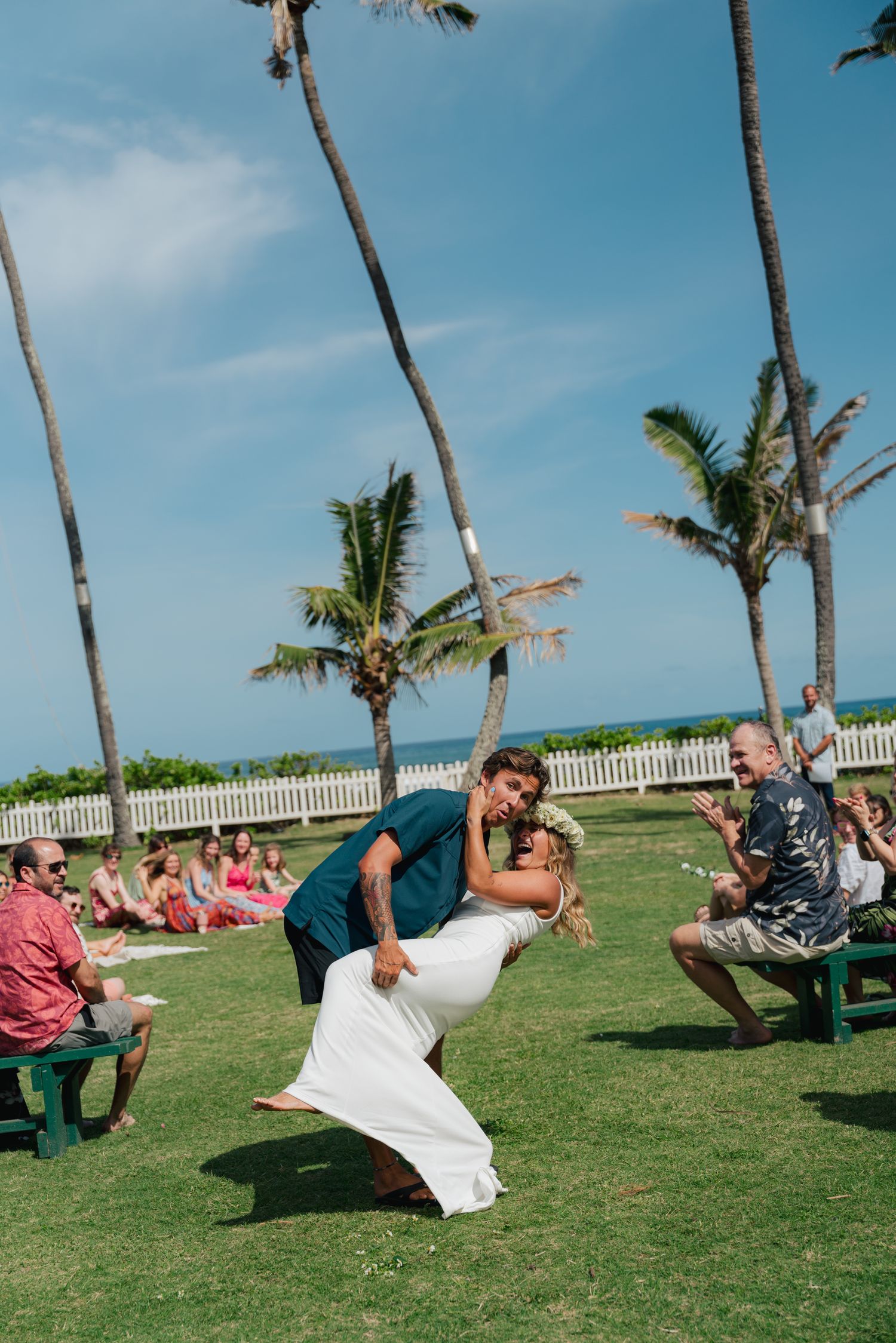man dipping his bride after walking down the aisle, North Shore of Oahu