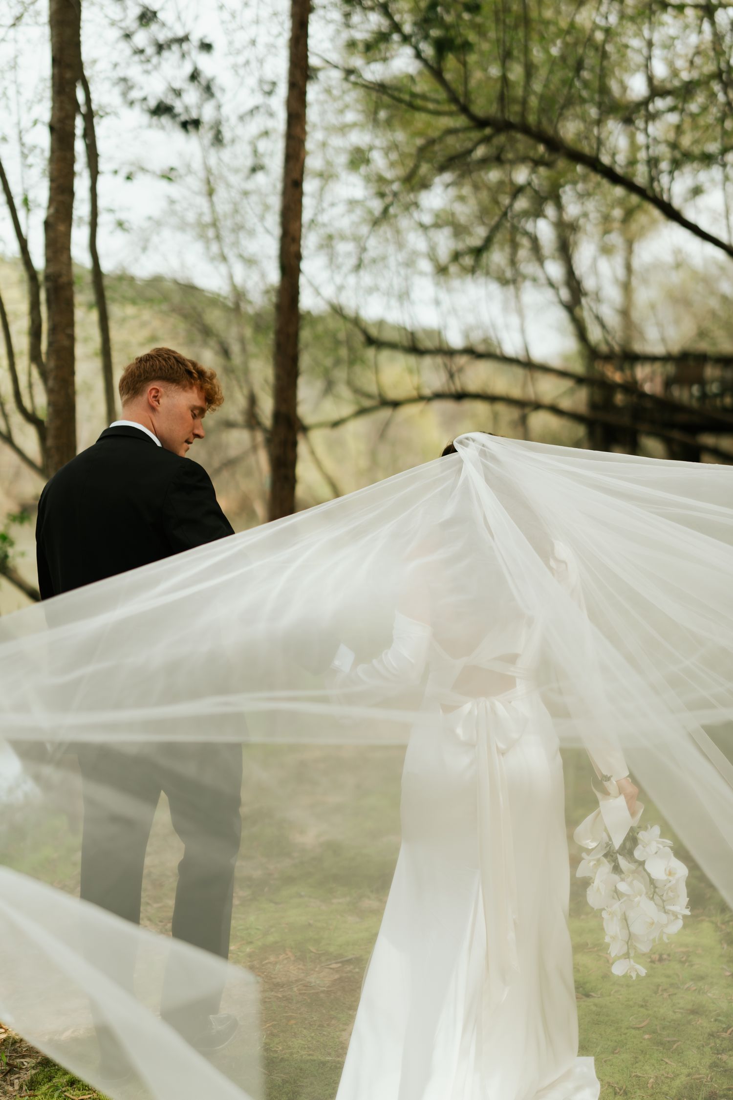 bride and groom, veil is blowing in the wind