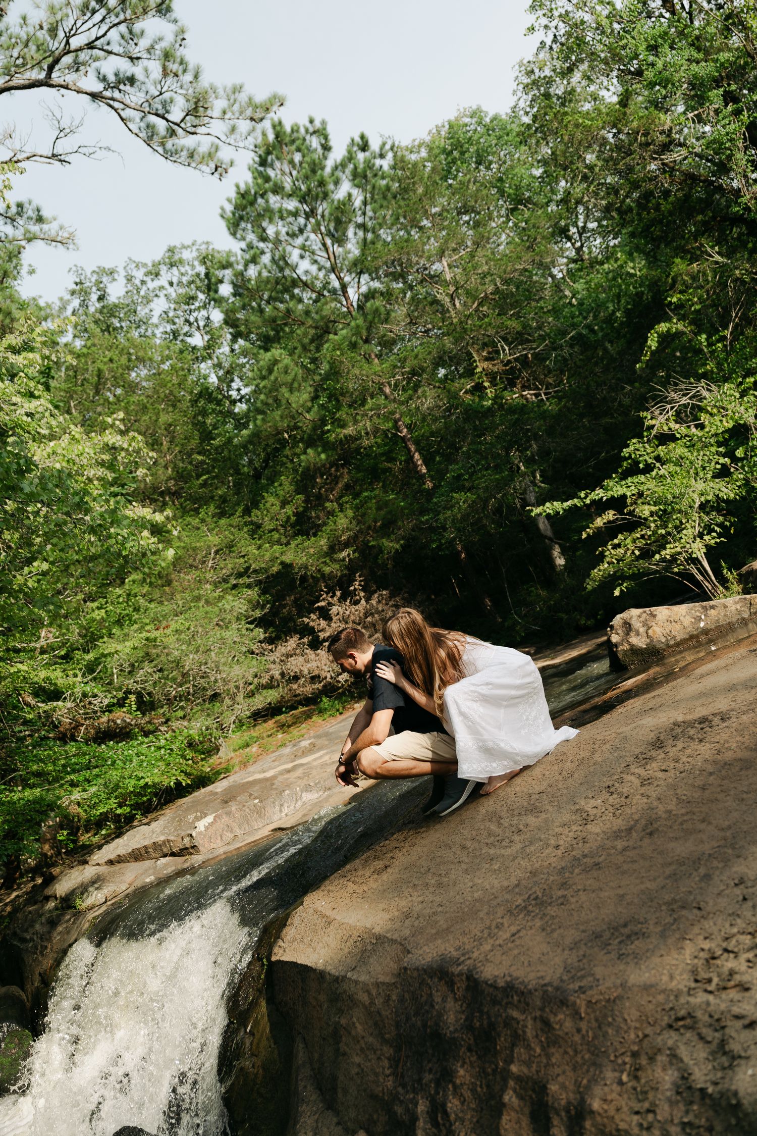 couple leaning over looking at a waterfall