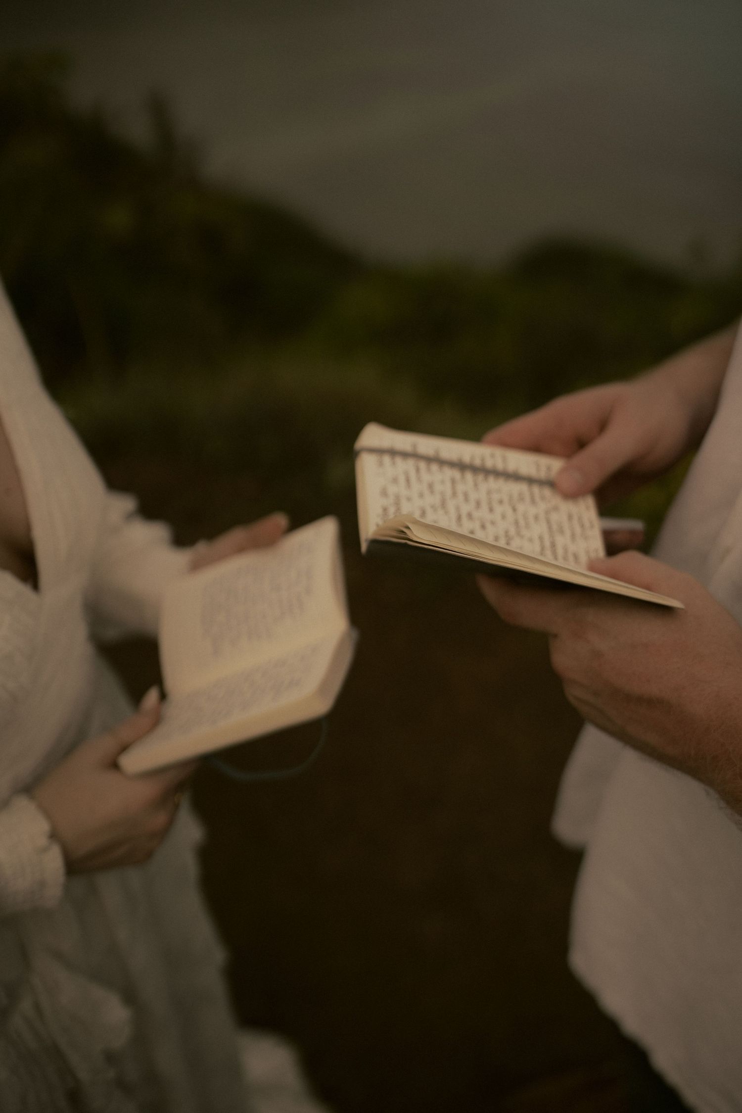 bride and groom holding vow books