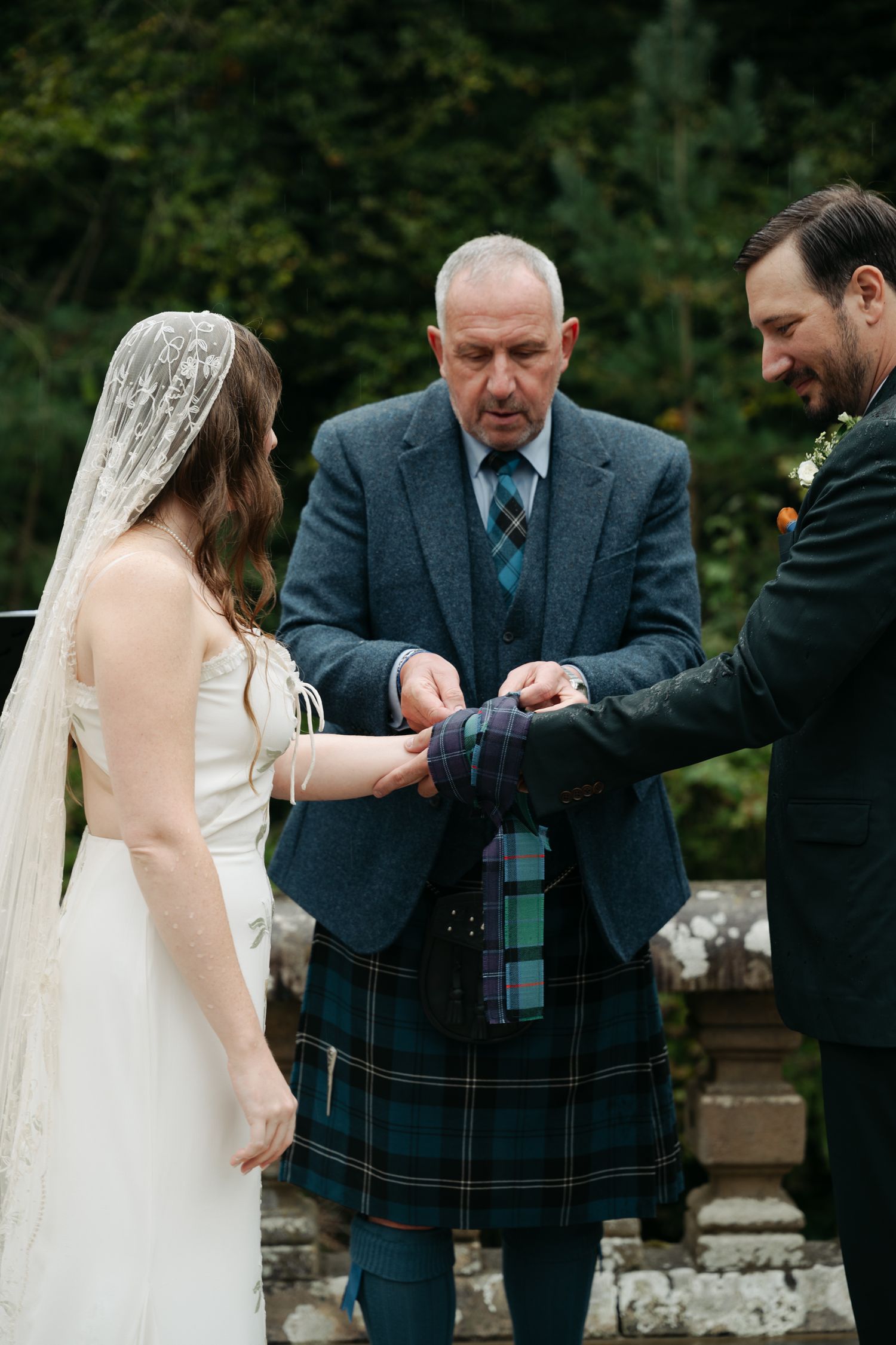 bride and groom, tying the know with a tie during the ceremony.