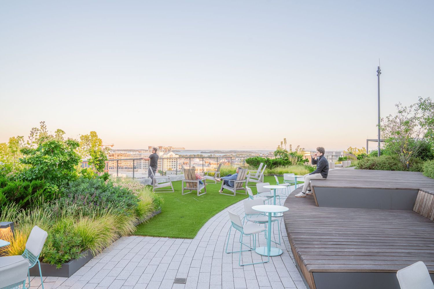 Rooftop deck featuring modern furniture and landscaping with panoramic city views.