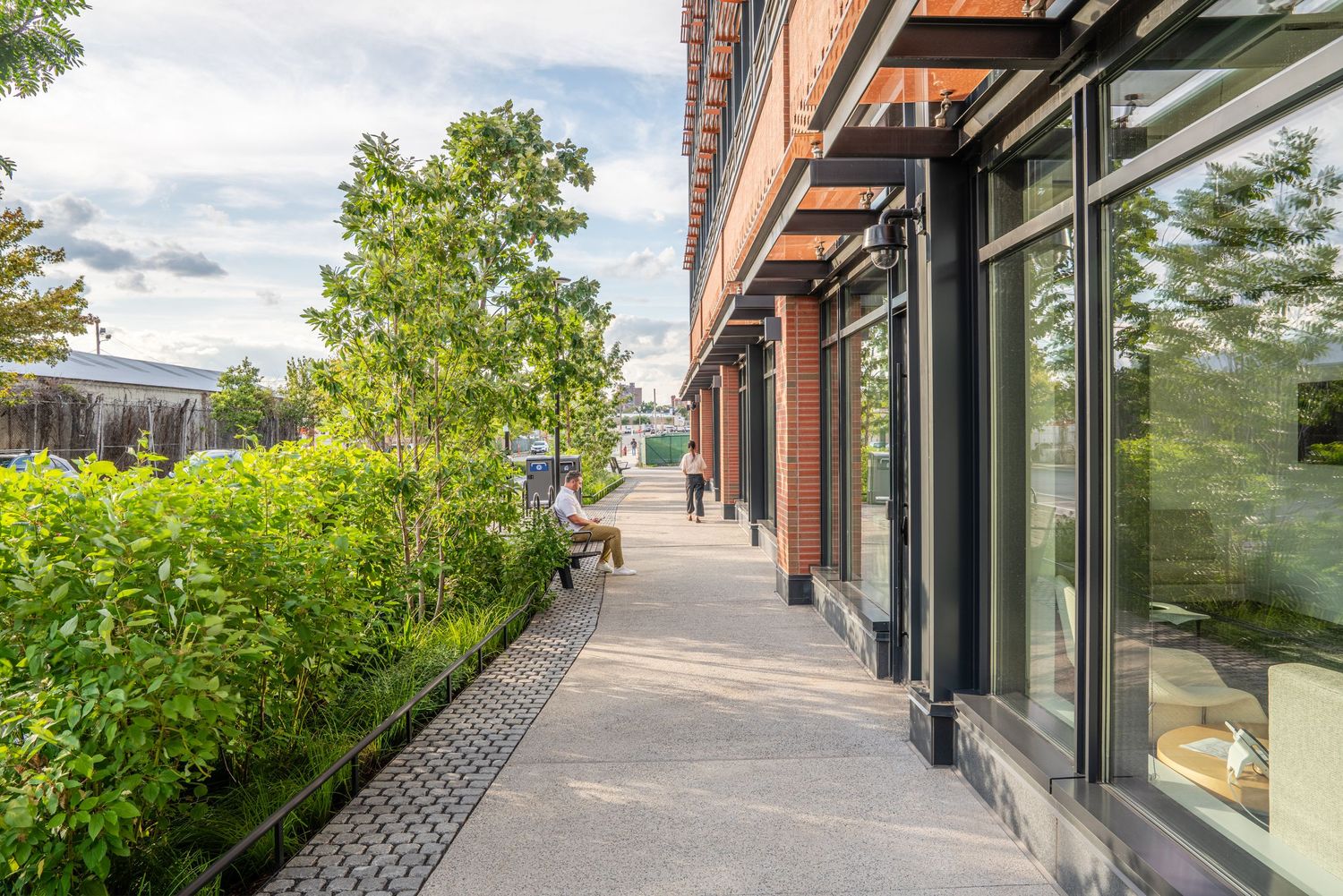 Commercial building exterior with paved walkway and integrated landscape design.