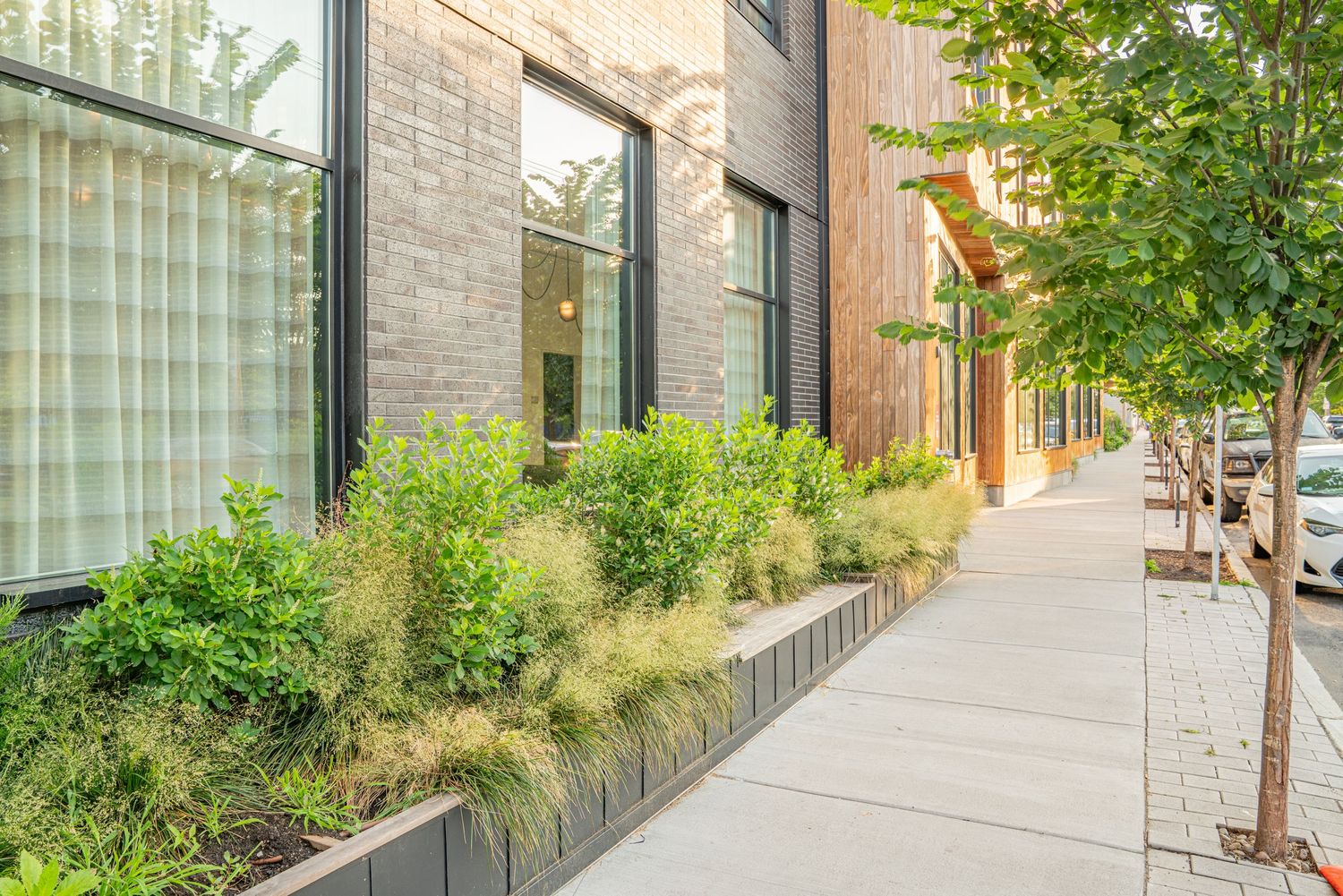 Glass-fronted modern building with landscaped walkway and architectural details.