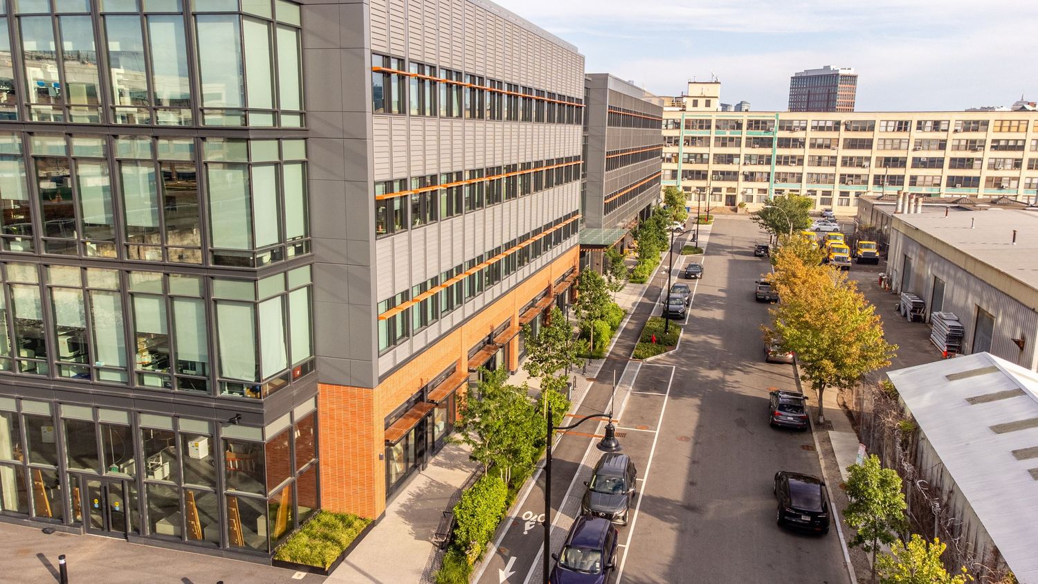 Contemporary office building exterior with glass windows and architectural details along an urban street.