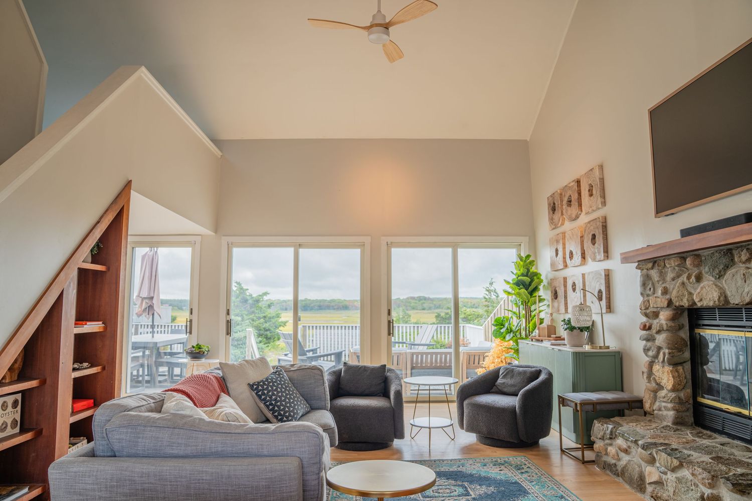 Bright living room interior with vaulted ceilings, exposed beams, and large windows offering natural light.