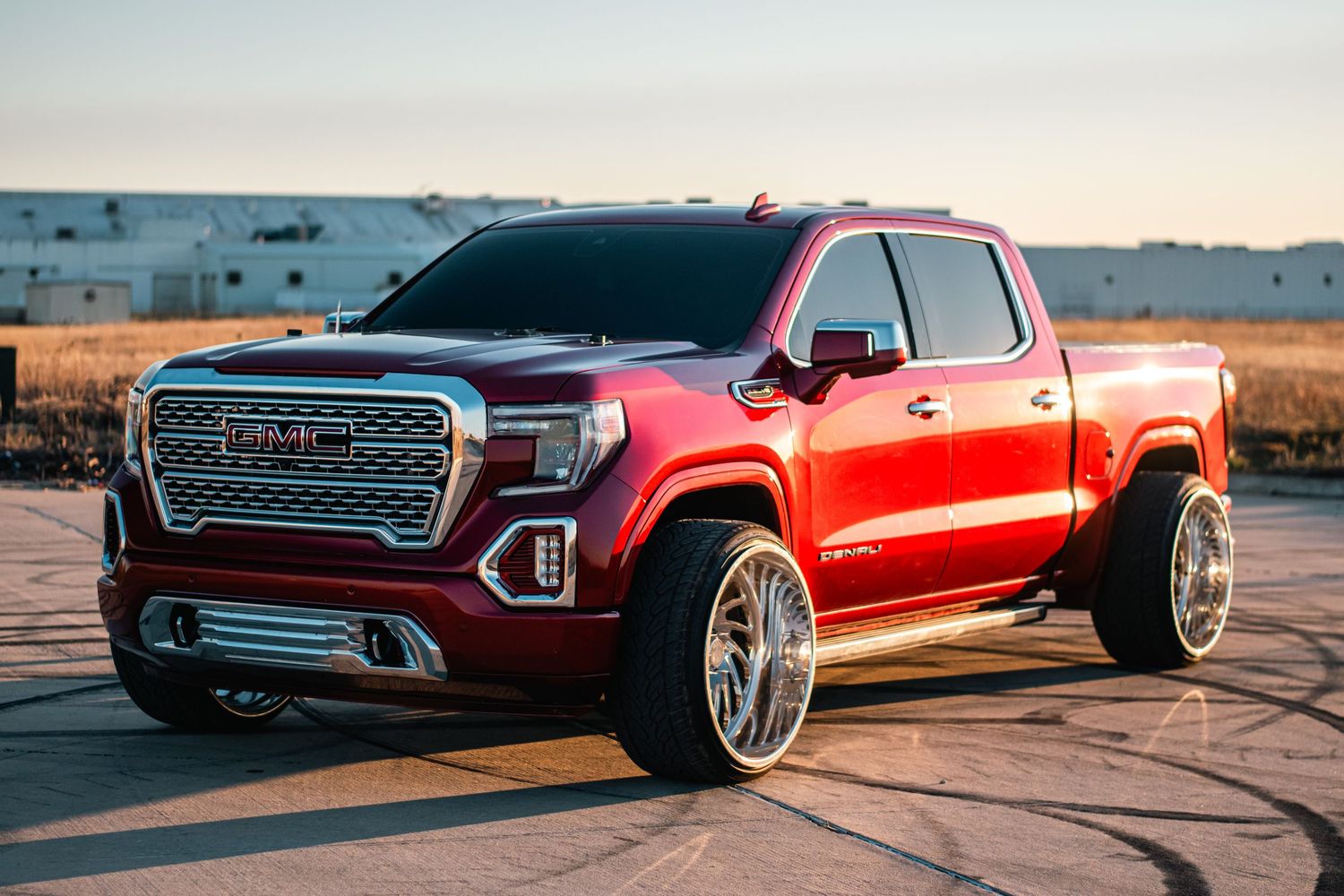 Custom GMC Sierra photography capturing bold design, lifted stance, chrome accents, and powerful presence in golden hour light.