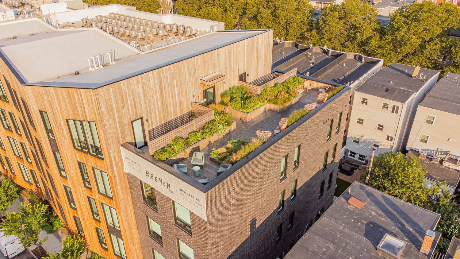 Panoramic aerial shot of residential buildings with flat roofs and surrounding urban development.