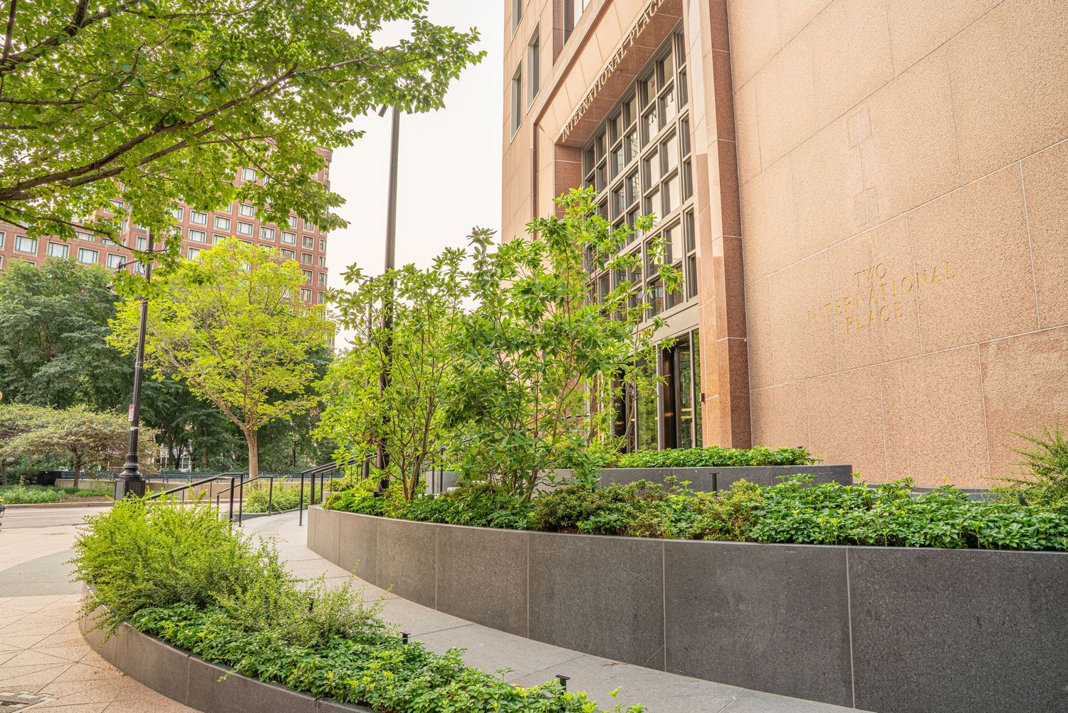 Landscaped pathway with planters and railings leading to building entrance.