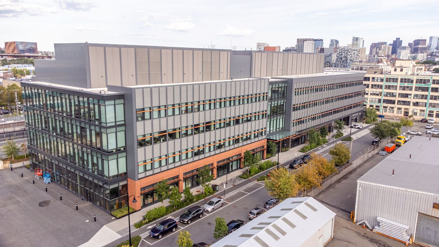 Aerial view of modern commercial buildings and urban development with glass facades and parking areas.