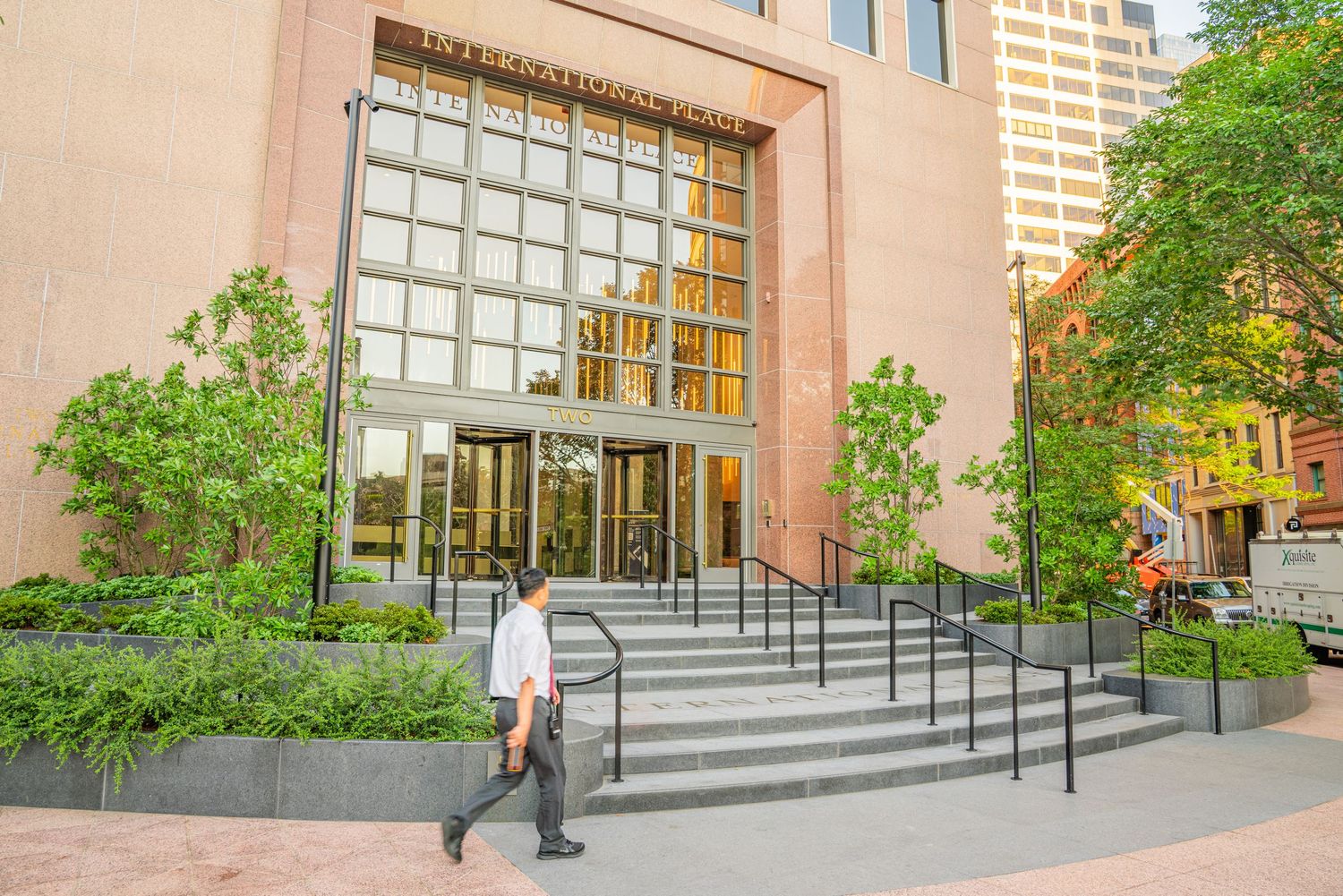 Building entrance with concrete stairs, metal railings and glass block windows.