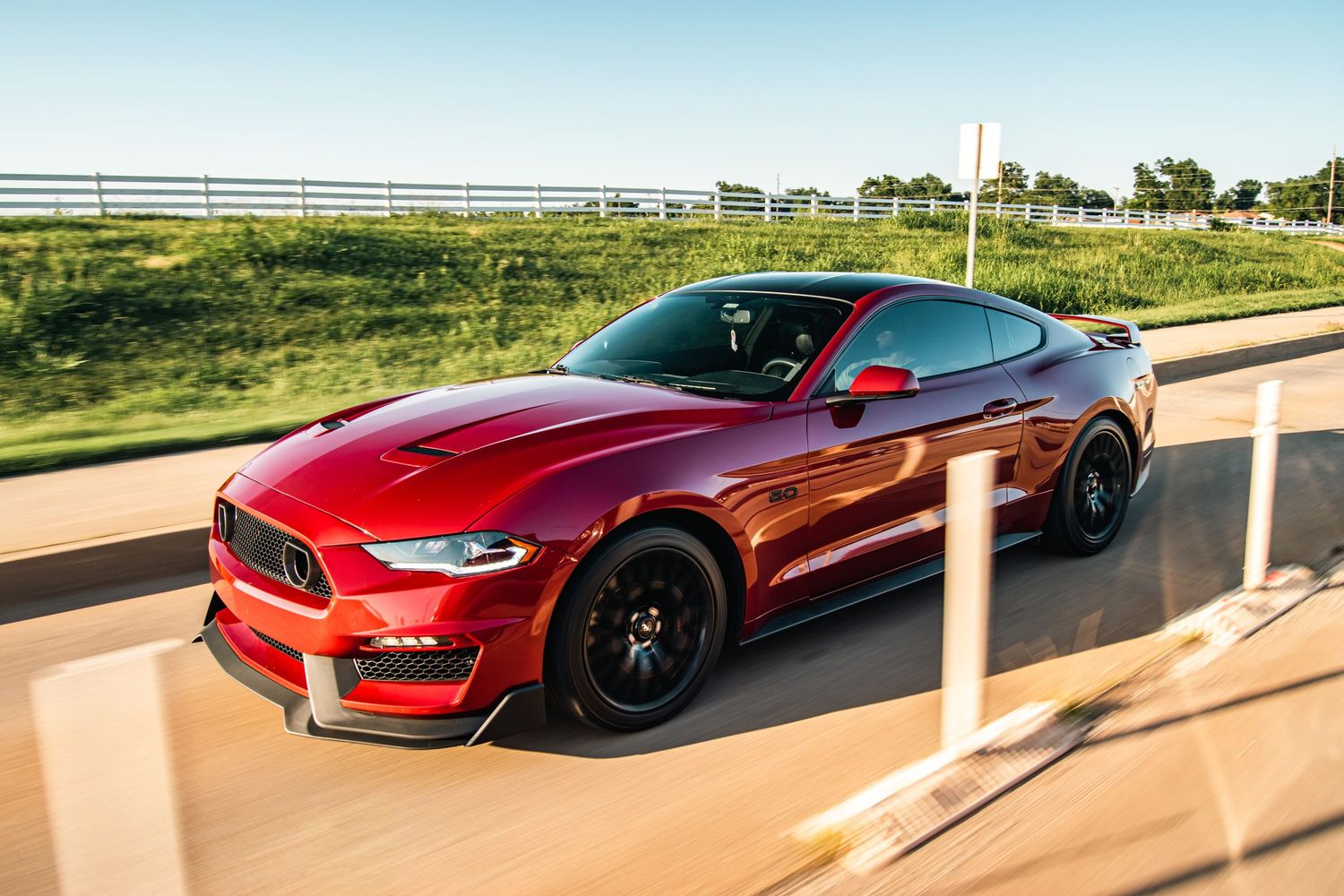 High-speed rolling shot of a red Ford Mustang, showcasing sleek design, motion blur, and powerful performance in golden hour light.