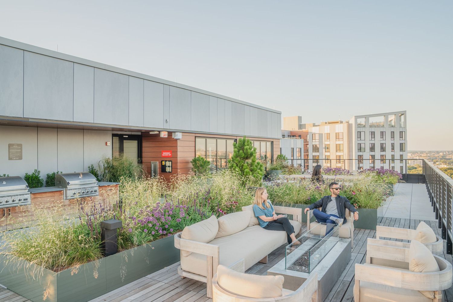 Modern rooftop terrace featuring built-in seating areas and landscaped garden elements.