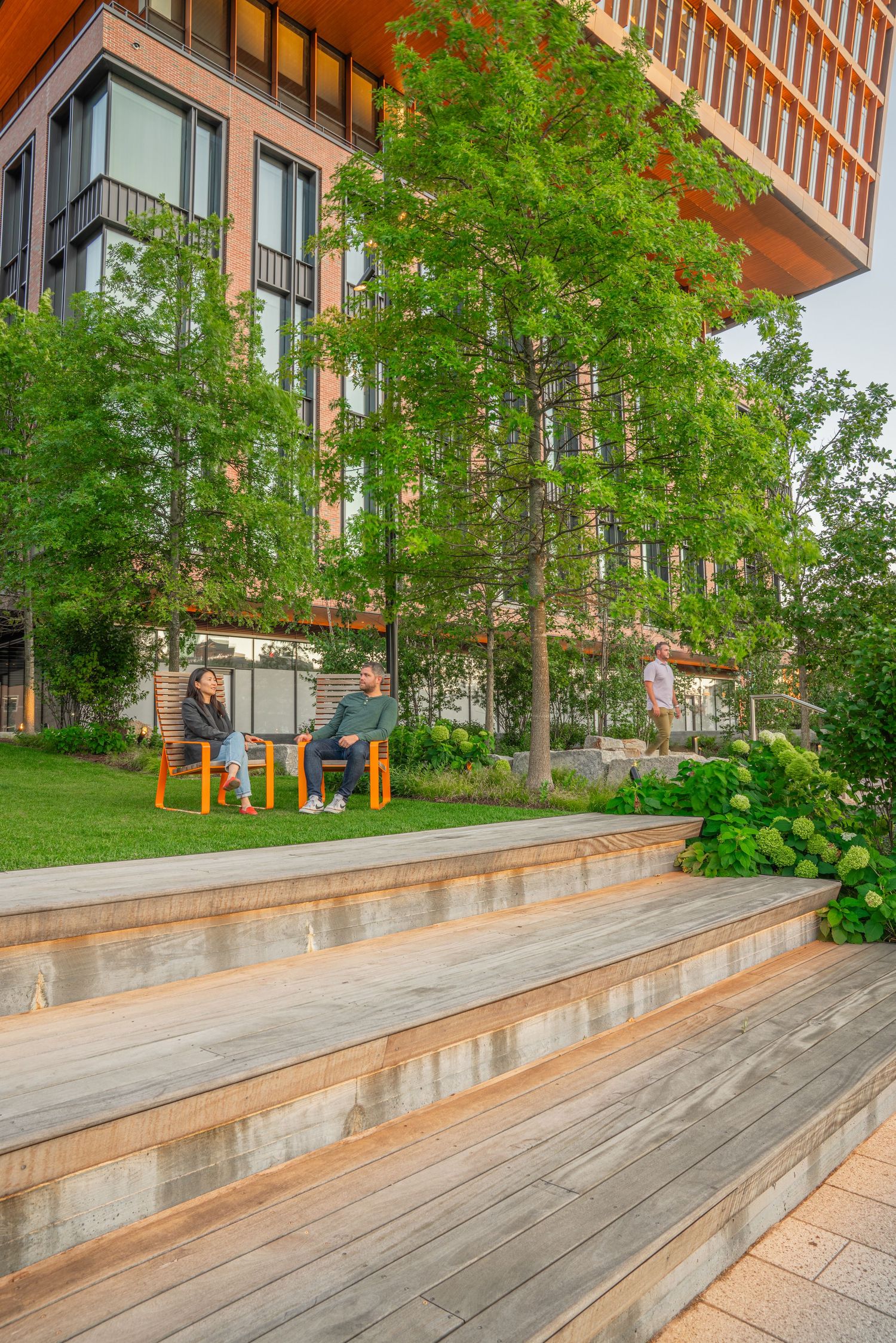 Tiered wooden steps with integrated planters create an outdoor amphitheater space.