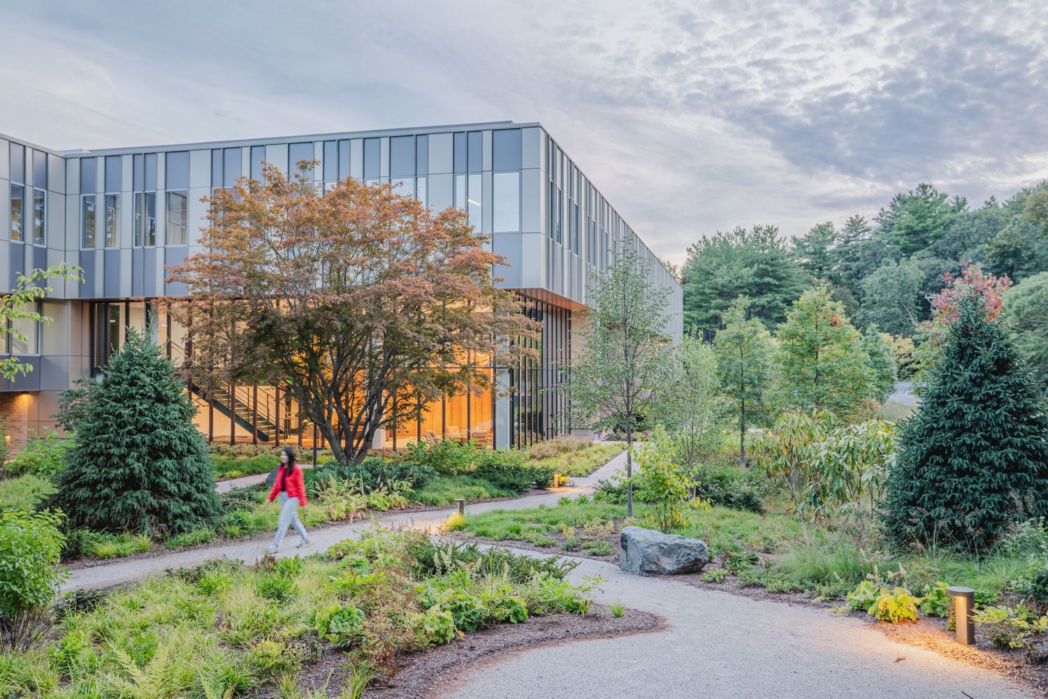 Modern office building exterior with curved architecture and landscaped gardens.