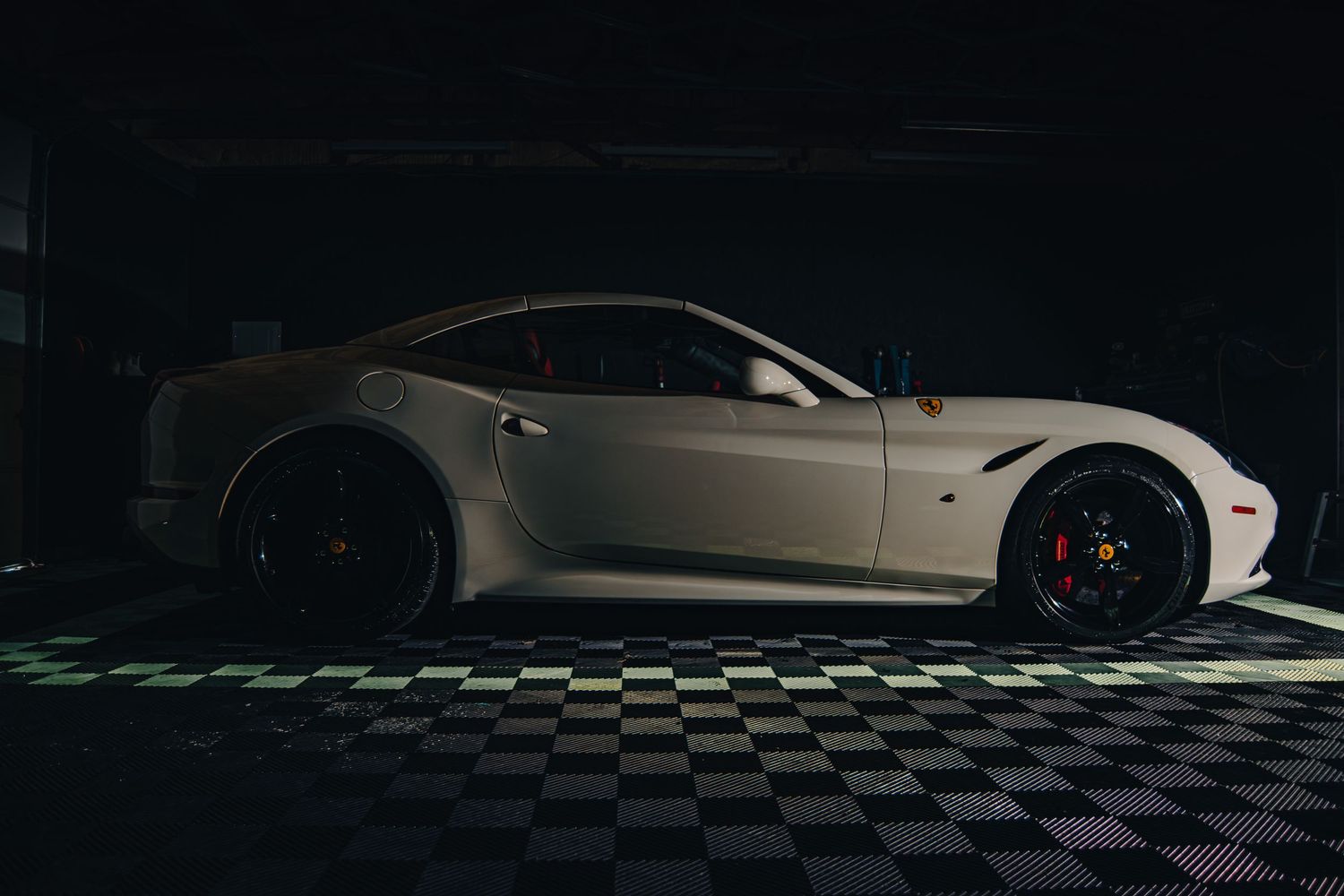Moody automotive photography of a Ferrari, captured in profile with dramatic lighting, sleek curves, and a bold luxury performance presence.