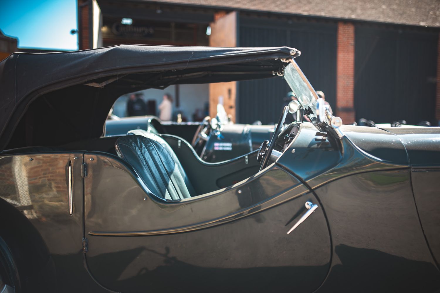 Close-up of a classic convertible car interior, showcasing sleek leather seats and vintage dashboard details.
