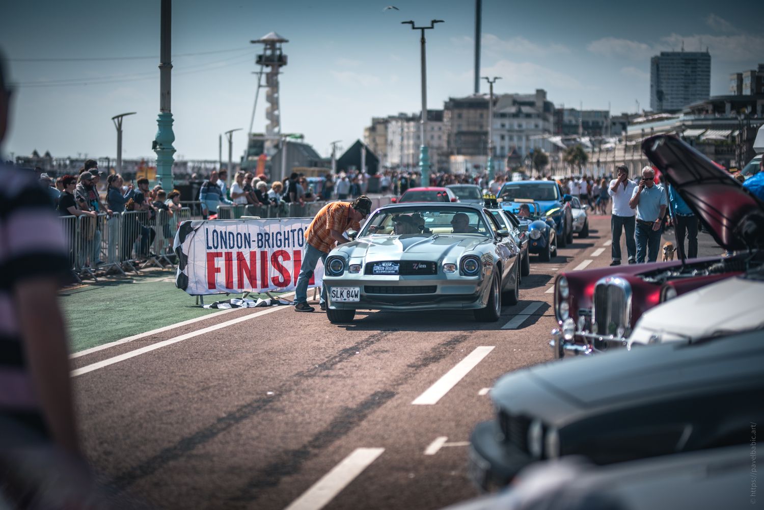 A classic car show on Brighton seafront with a blue car near a 