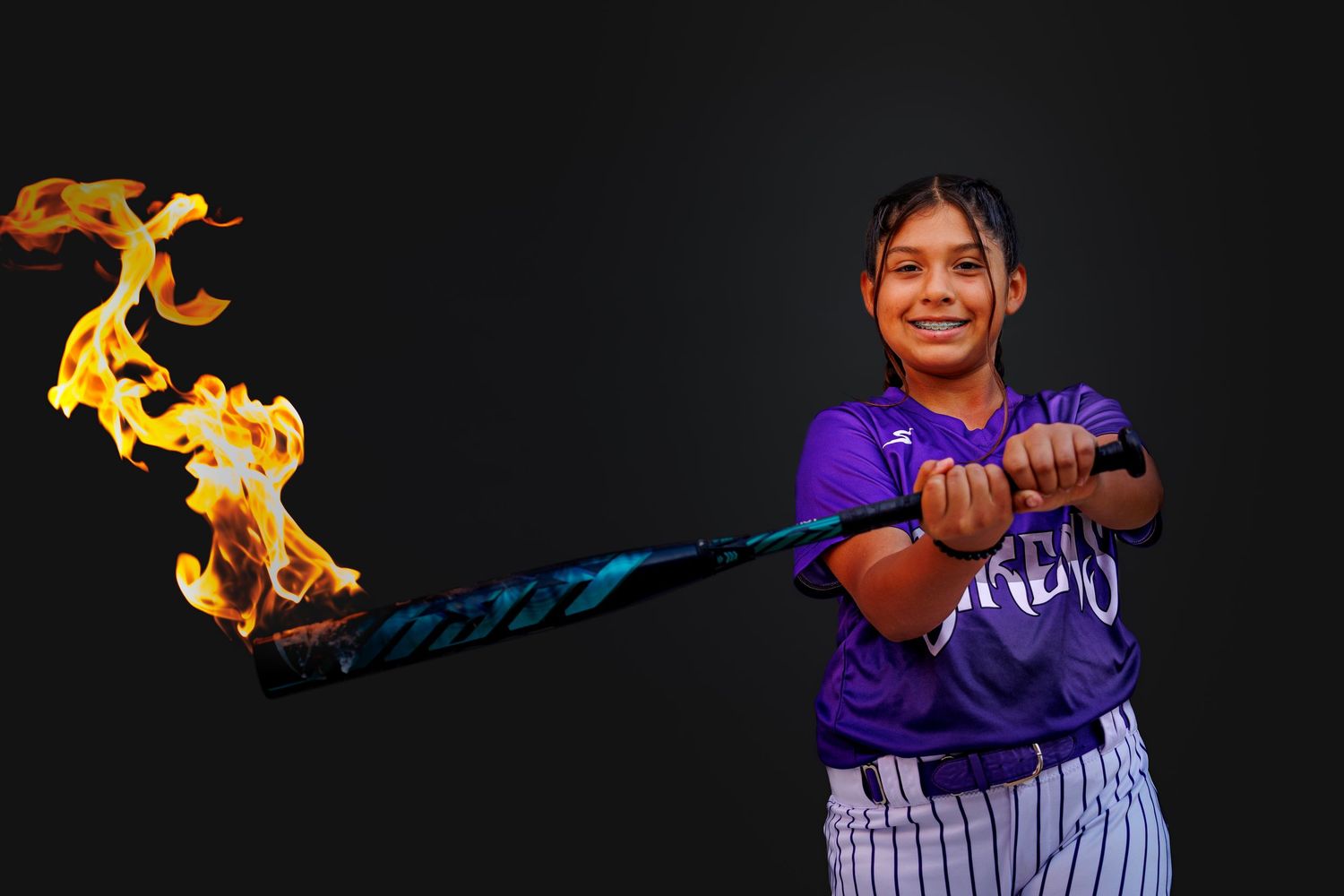 Baseball player in purple jersey dramatically swings a bat engulfed in blue and orange flames against dark background.