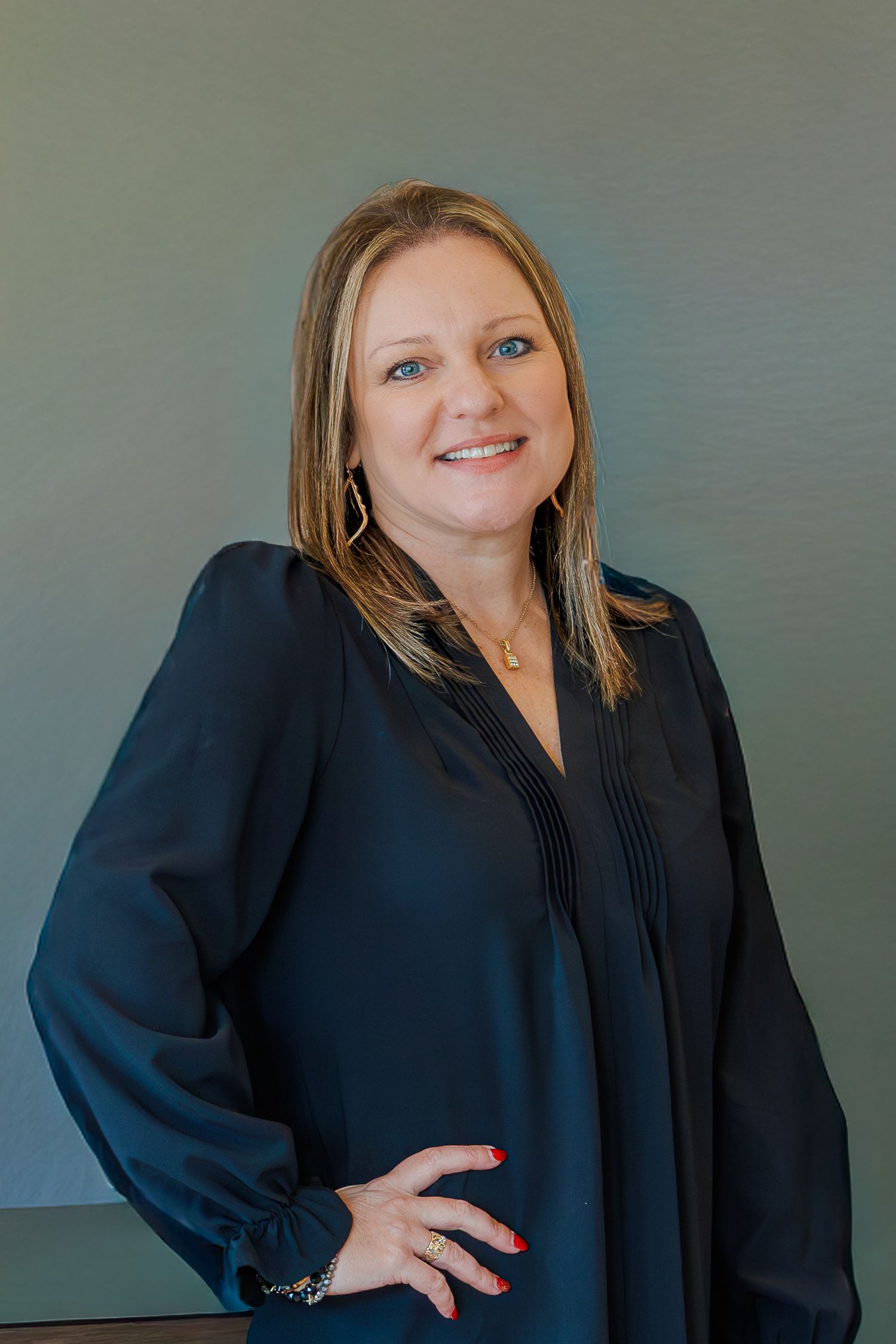 Professional headshot of someone wearing a black blouse against a gray background in multiple poses.