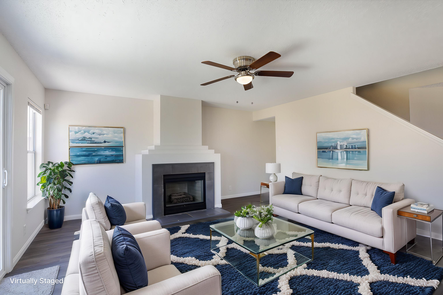 Family room with comfortable seating arrangement and blue carpeting facing entertainment center.