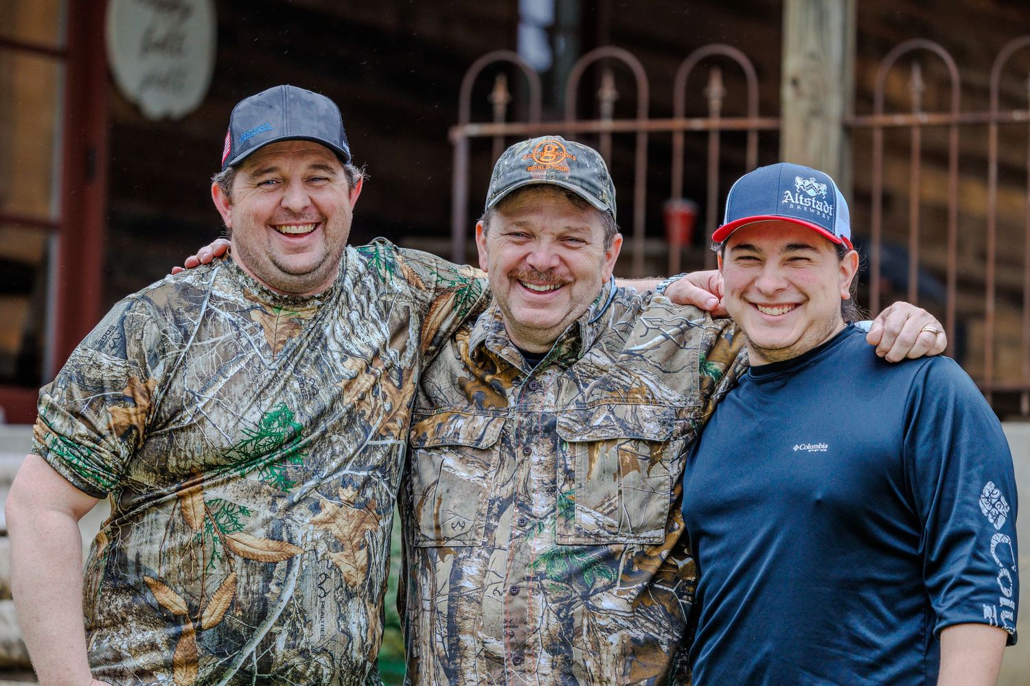 Group of friends in hunting camo and casual wear posing together outdoors.