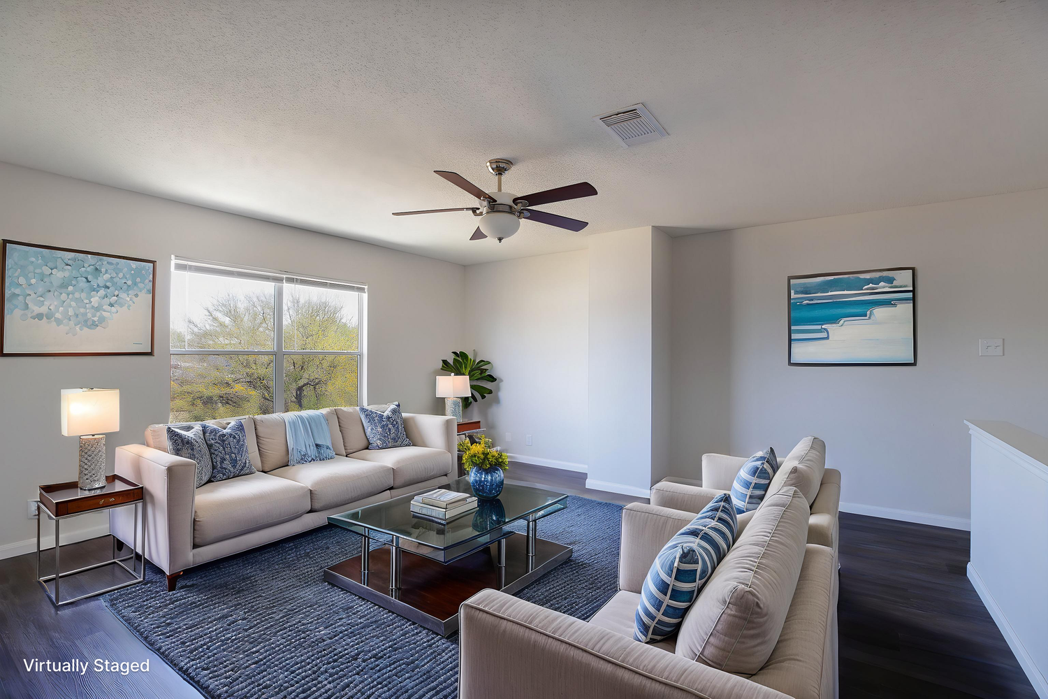 Living room showcasing modern gray sectional sofa and coastal-themed wall art.