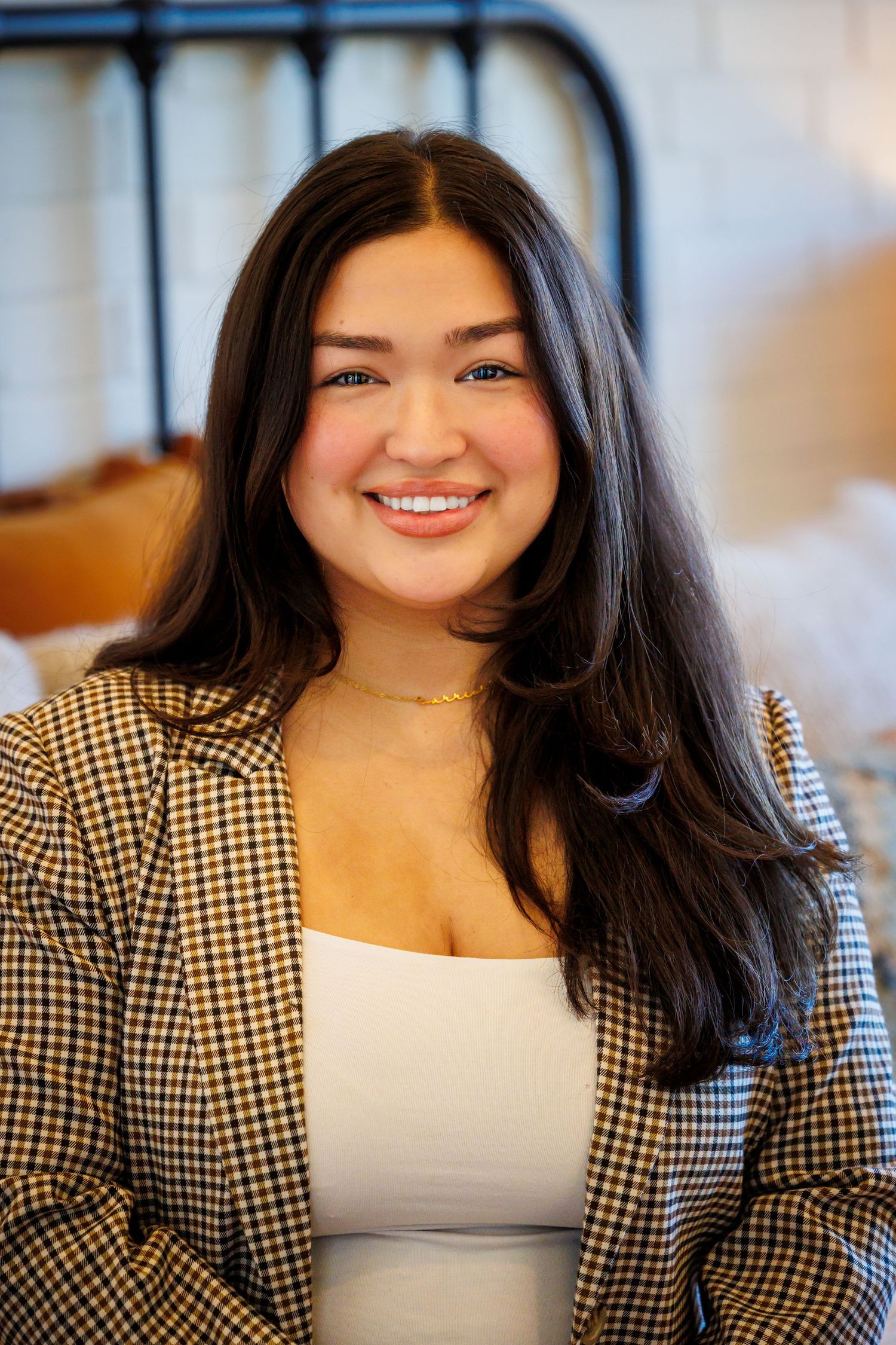 Professional portrait series showing a black and white checkered blazer paired with a white top in an office setting.