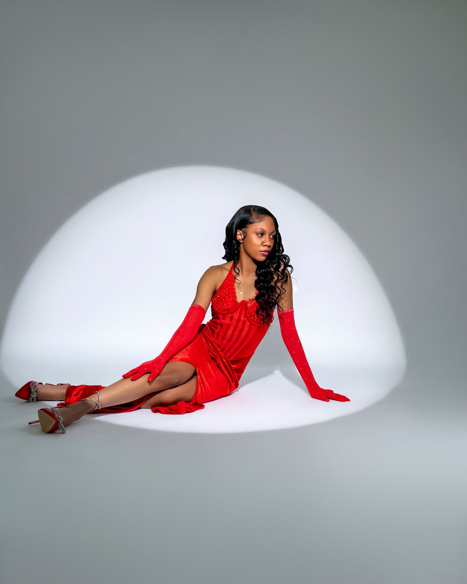 Fashion photography series featuring red dress and dramatic poses on grey backdrop.