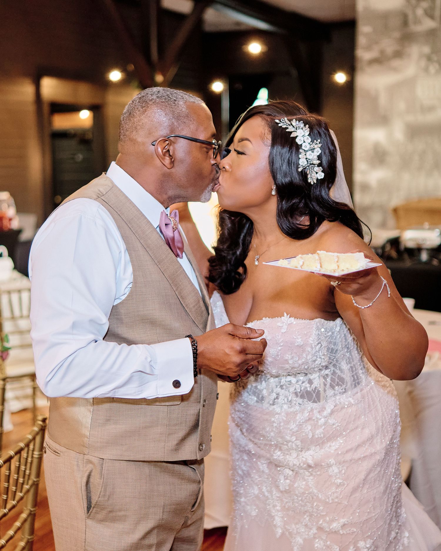 A couple shares an intimate moment during their wedding reception, with bride in white lace dress.