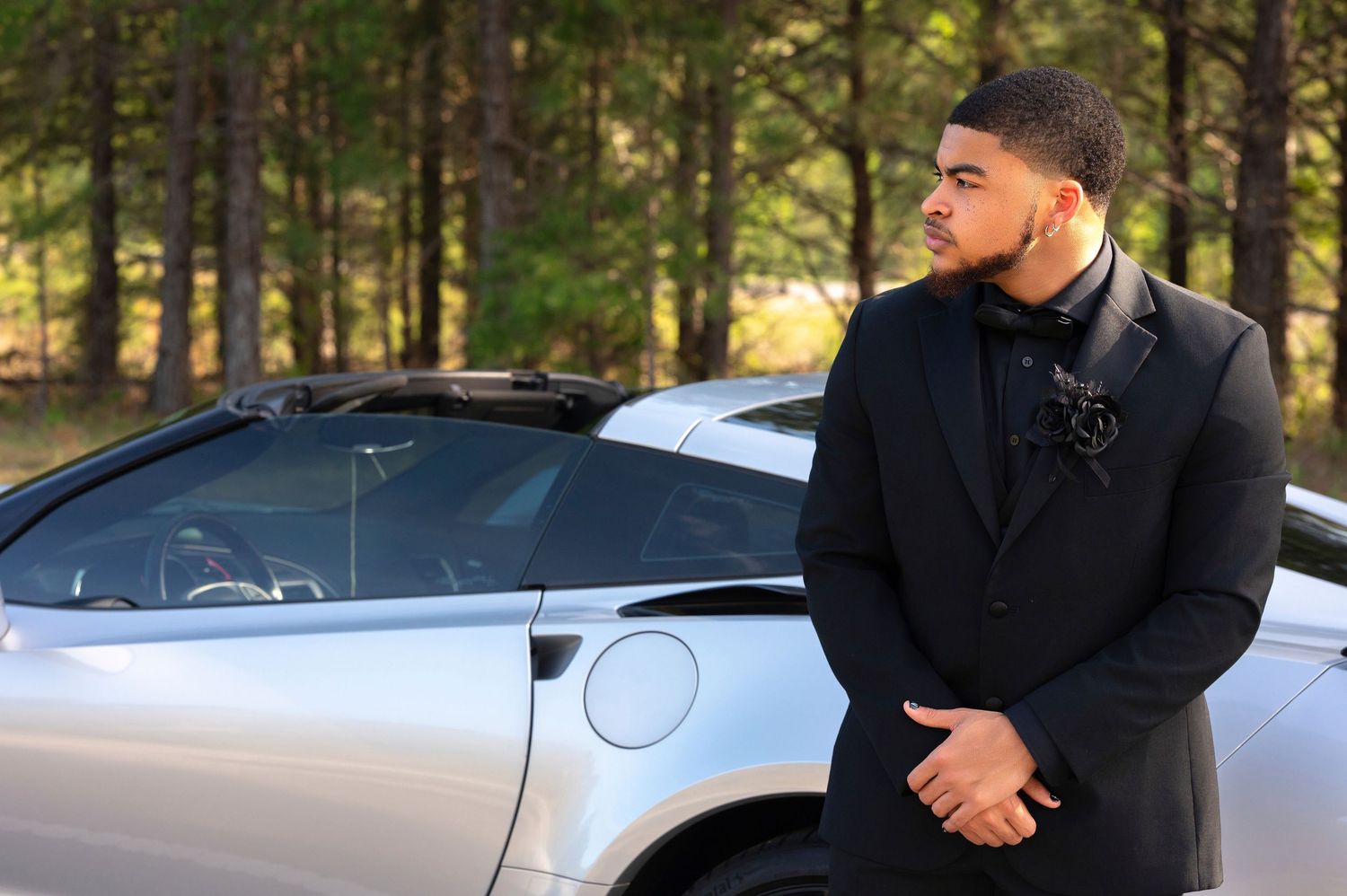 Professional outdoor photo shoot featuring luxury cars and formal attire.