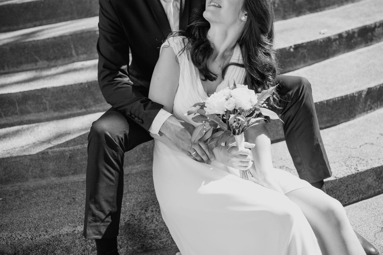 A tender wedding moment captured on outdoor stone steps.