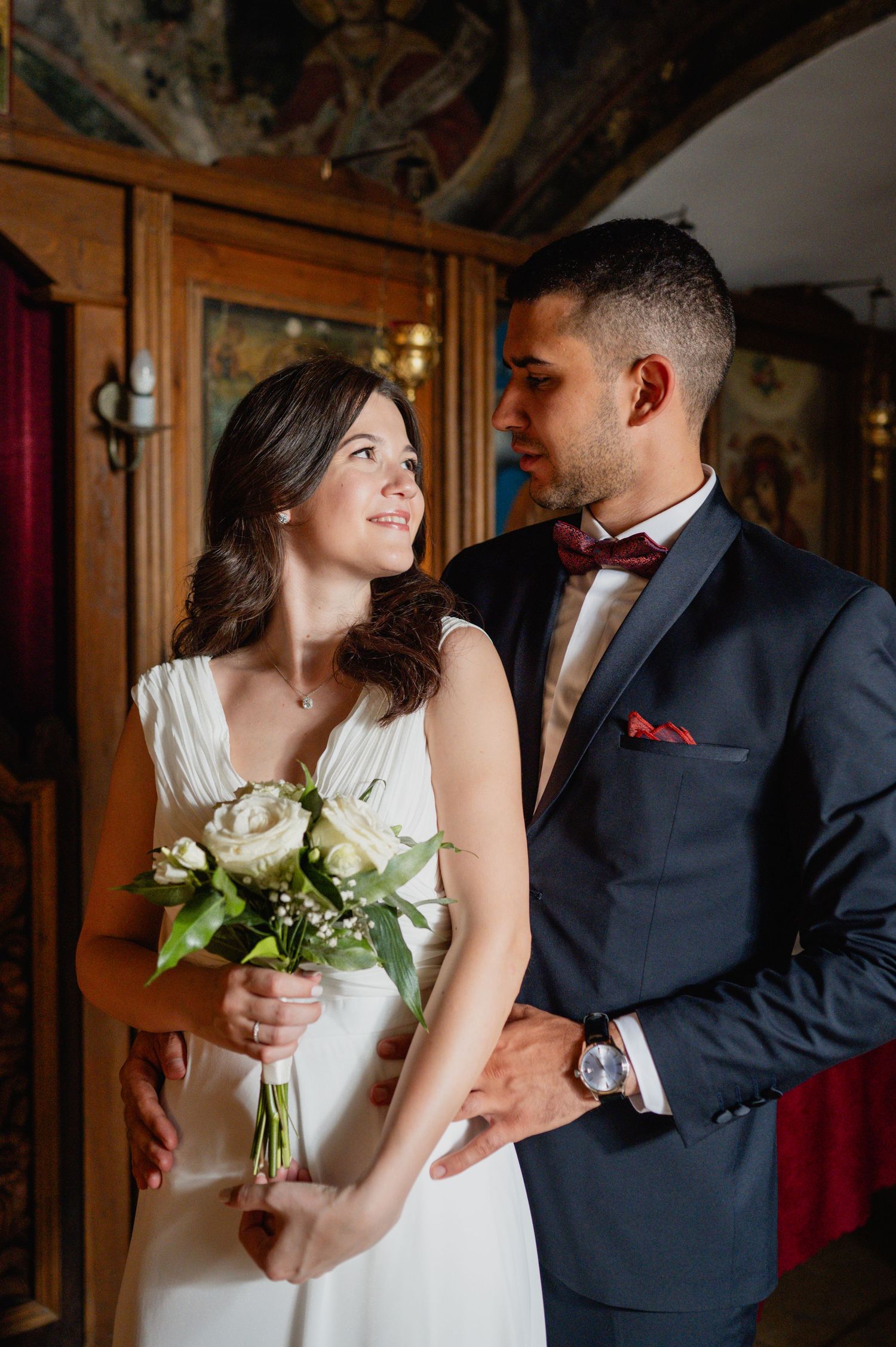 An intimate wedding moment captured in a warmly lit interior with wooden details.