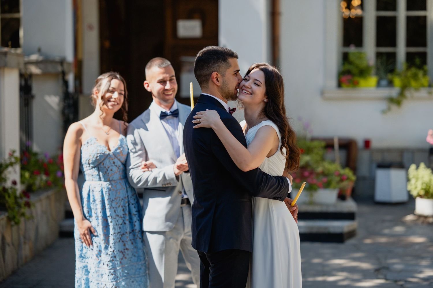 Wedding guests gather around to celebrate during an outdoor ceremony.