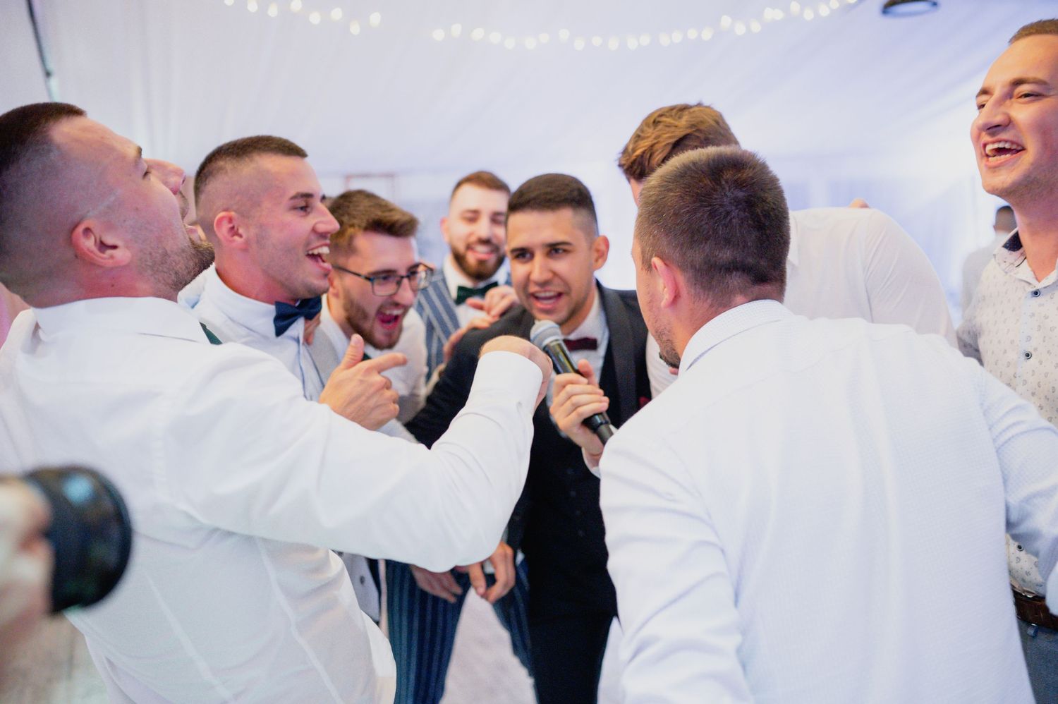 Wedding celebration showing guests in formal attire enjoying festivities indoors.