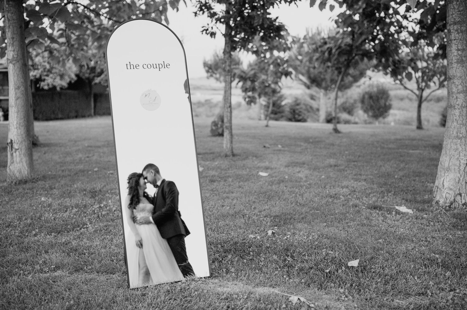 Black and white photos showing outdoor wedding moments under trees.