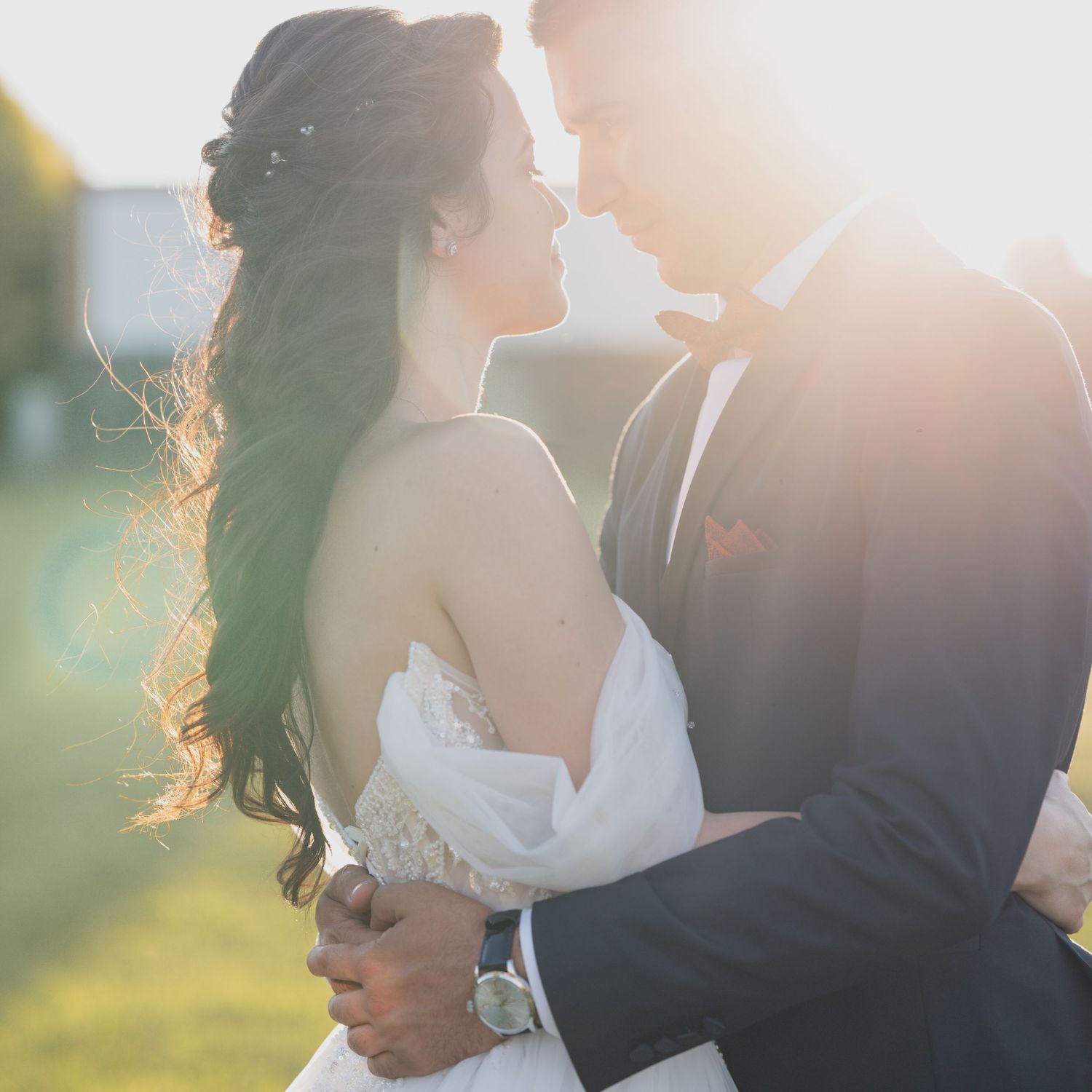 Sun-drenched wedding portrait with romantic backlit glow.