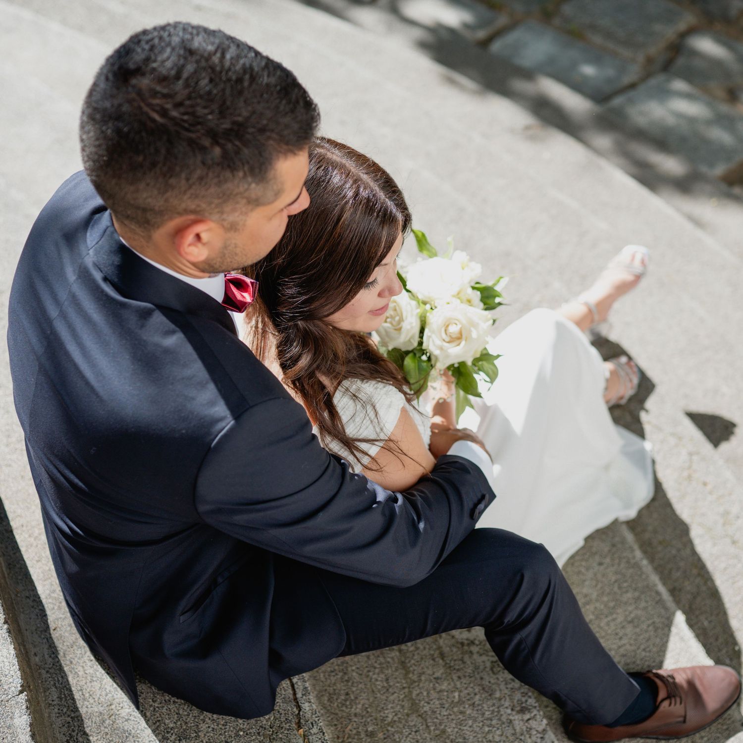 Overhead view of a couple sitting together on outdoor steps.