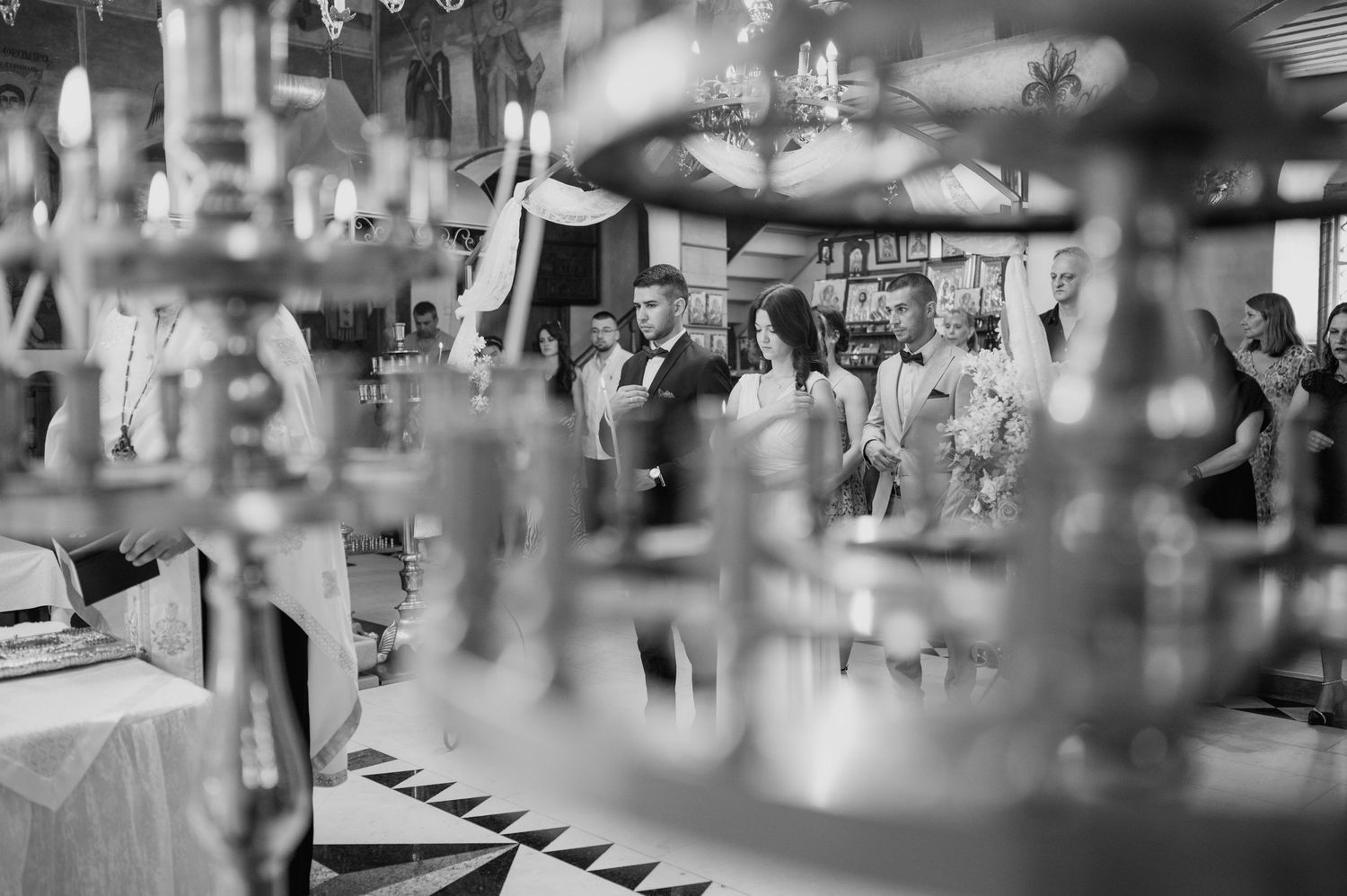 Blurred wedding reception details with glasses and decorative elements in the foreground.