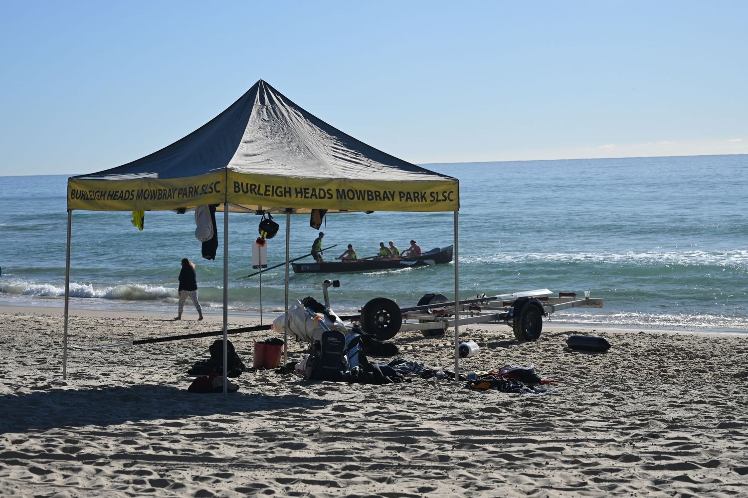 Burleigh Heads Mowbray Park branded canopy tent shelters surf boat equipment on sandy beach.