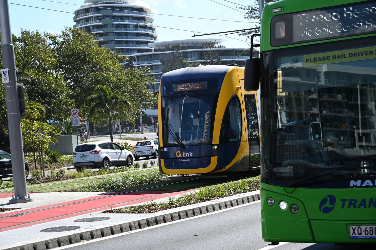 Gold Coast light rail tram and green double-decker bus at Surfers Paradise transit hub, Queensland, Australia.