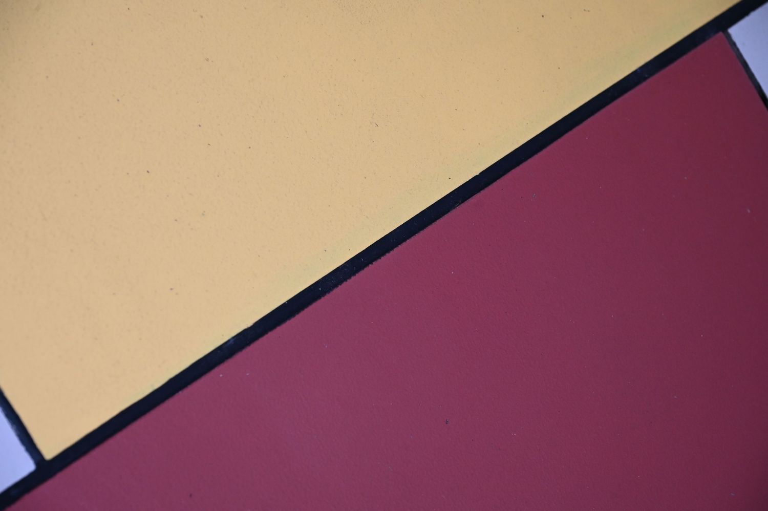 Abstract geometric background with yellow and burgundy color blocks divided by diagonal lines.