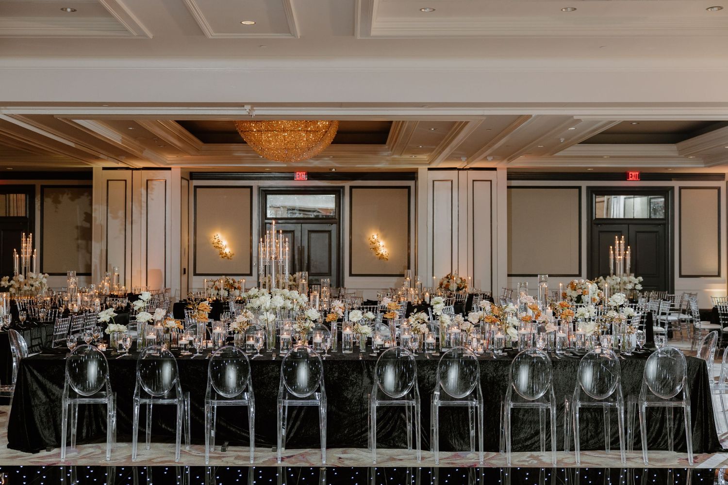 Elegant modern ballroom with silver candelabras and crystal chandeliers set up for a wedding reception.