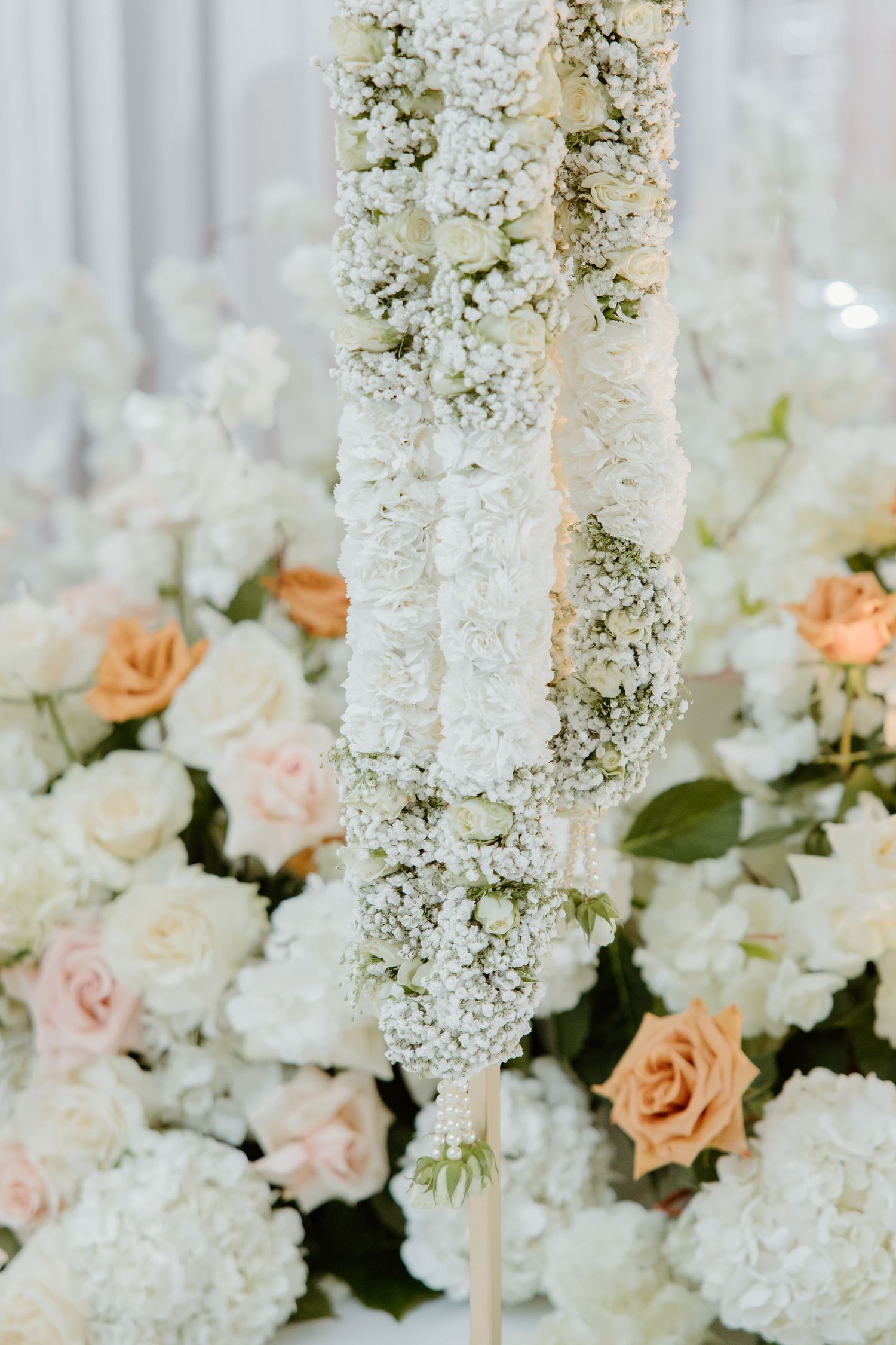 Delicate white floral arrangements with baby's breath and blush roses creating an elegant wedding backdrop.