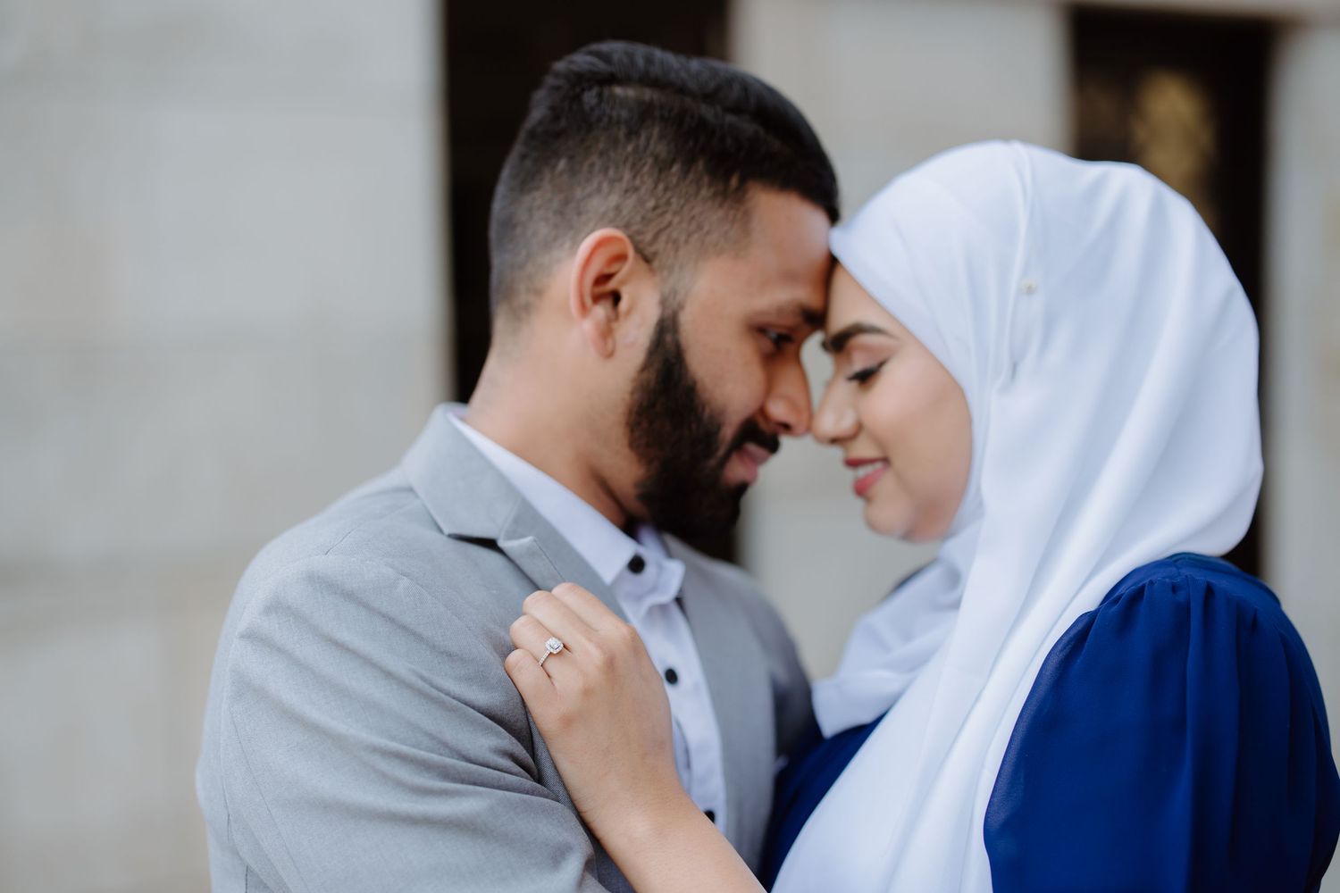 A tender moment between a couple in traditional dress as they embrace outdoors in soft lighting.
