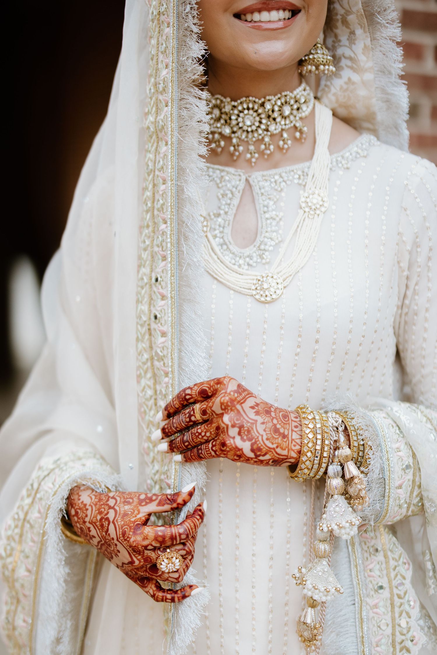 Detail shots of traditional South Asian bridal jewelry and henna-adorned hands in white attire.