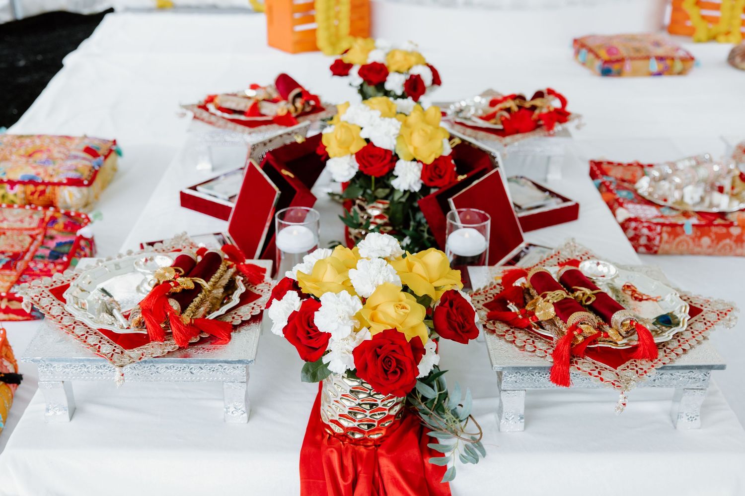 Red and yellow folded decorative Chinese New Year money envelopes scattered on white surface with festive ornaments.