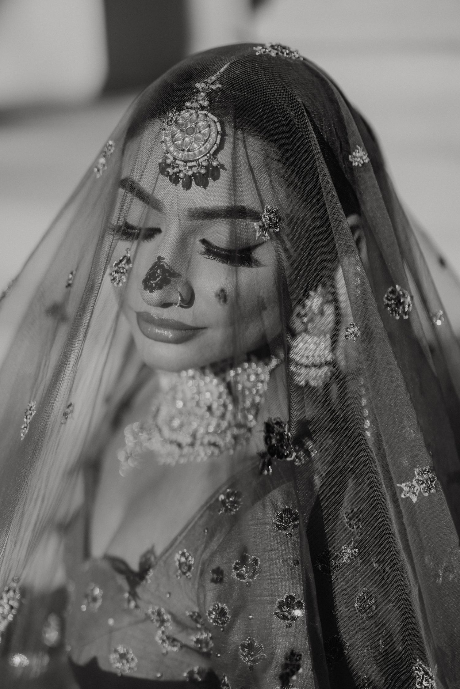 Black and white portrait series showing a bride in an ornate South Asian wedding veil with traditional jewelry and embellishments.